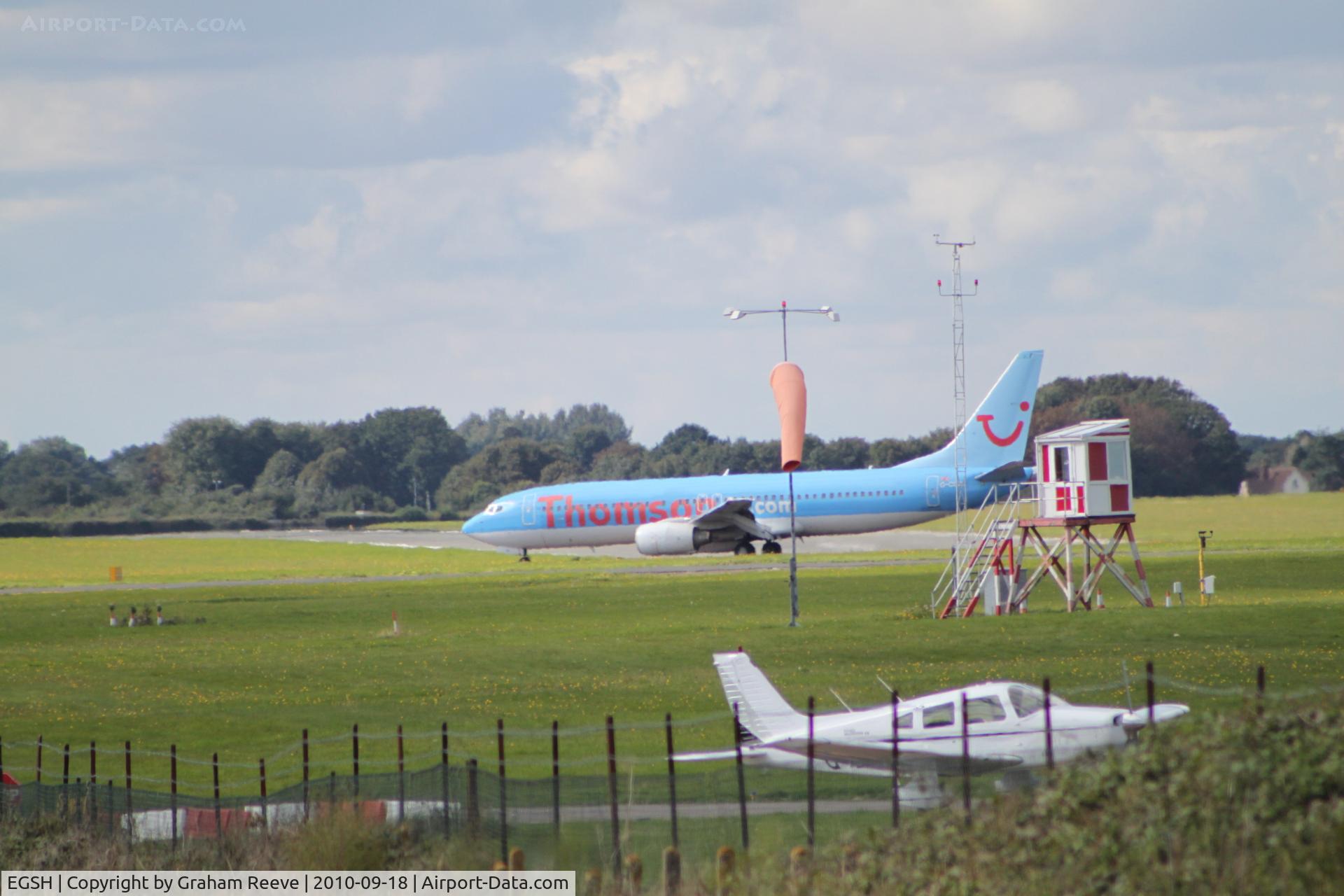 Norwich International Airport, Norwich, England United Kingdom (EGSH) - TUI 737 taxi's in whilst a Cherokee awaits departure.