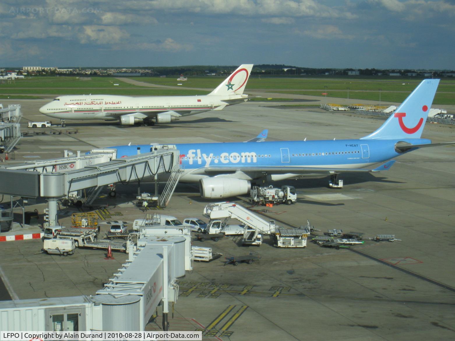 Paris Orly Airport, Orly (near Paris) France (LFPO) - Part view on the southeastern side from the observation deck of South terminal. Royal Air Maroc 747-428 CN-RGA was on push-back while Corsairfly A330-243 F-HCAT was being serviced in anticipation of a return to Miami