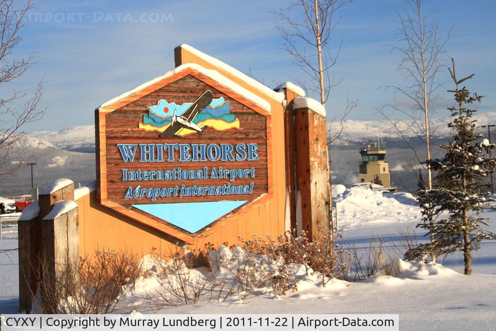 Whitehorse International Airport, Whitehorse, Yukon Canada (CYXY) - The sign at the entrance to the airport, with the control tower in the background.