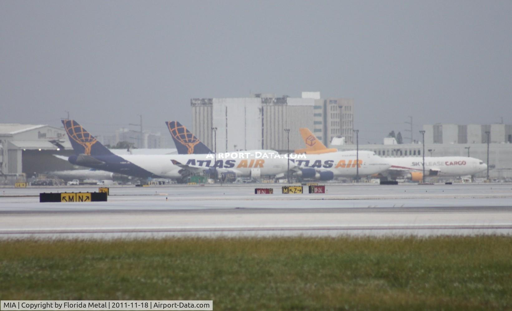 Miami International Airport (MIA) - Rain starting on east end, which means I will have to run to the car again - Atlas 747-400F and 200F in picture with Centurion MD-11F in background