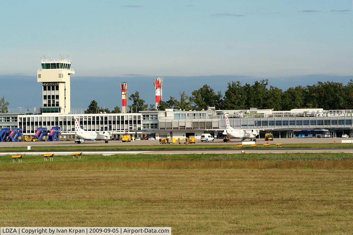 Zagreb Pleso Airport, Zagreb Croatia (LDZA) - Look over the fence shows control tower and on tarmac are visible two DHC-8-402Q airplanes from Croatia Airlines fleet