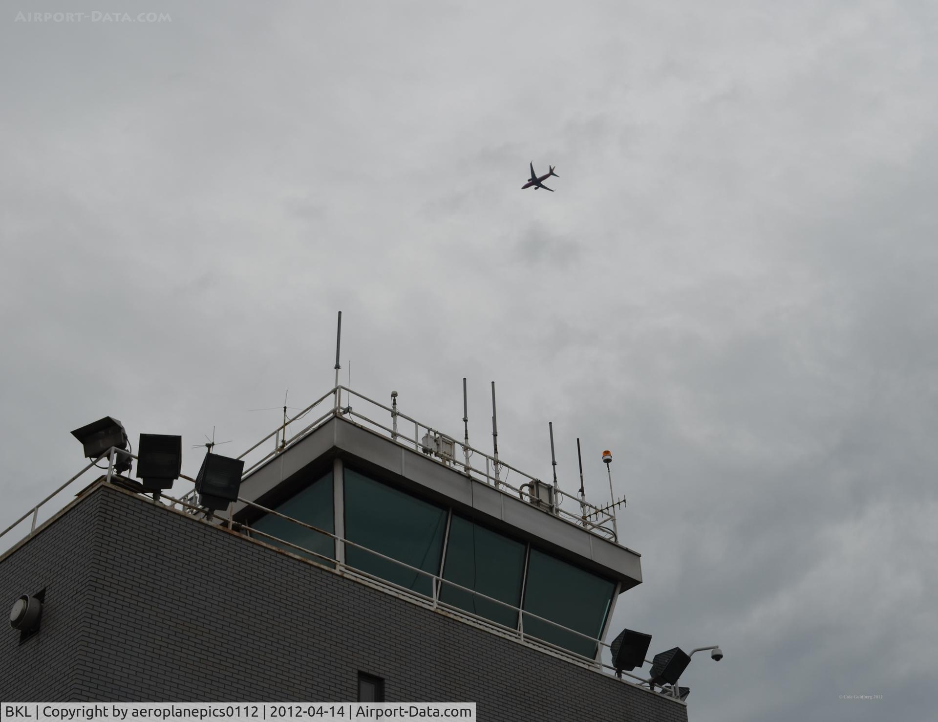 Burke Lakefront Airport (BKL) - A Southwest Airlines 737 is seen flying over the Air Traffic Control Tower on a rainy, cloudy day at Burke Lakefront Airport. 