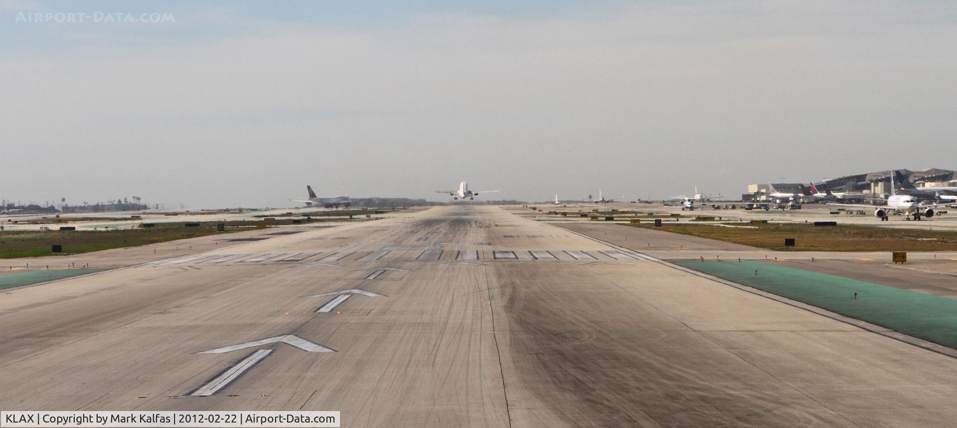 Los Angeles International Airport (LAX) - On the left, a Lufthansa 744 is arriving from Frankfurt. in the center is a Delta A319 departing RWY 25R to Salt Lake City, and to the right on TWY B is a United A319 bound for Los Cabos.