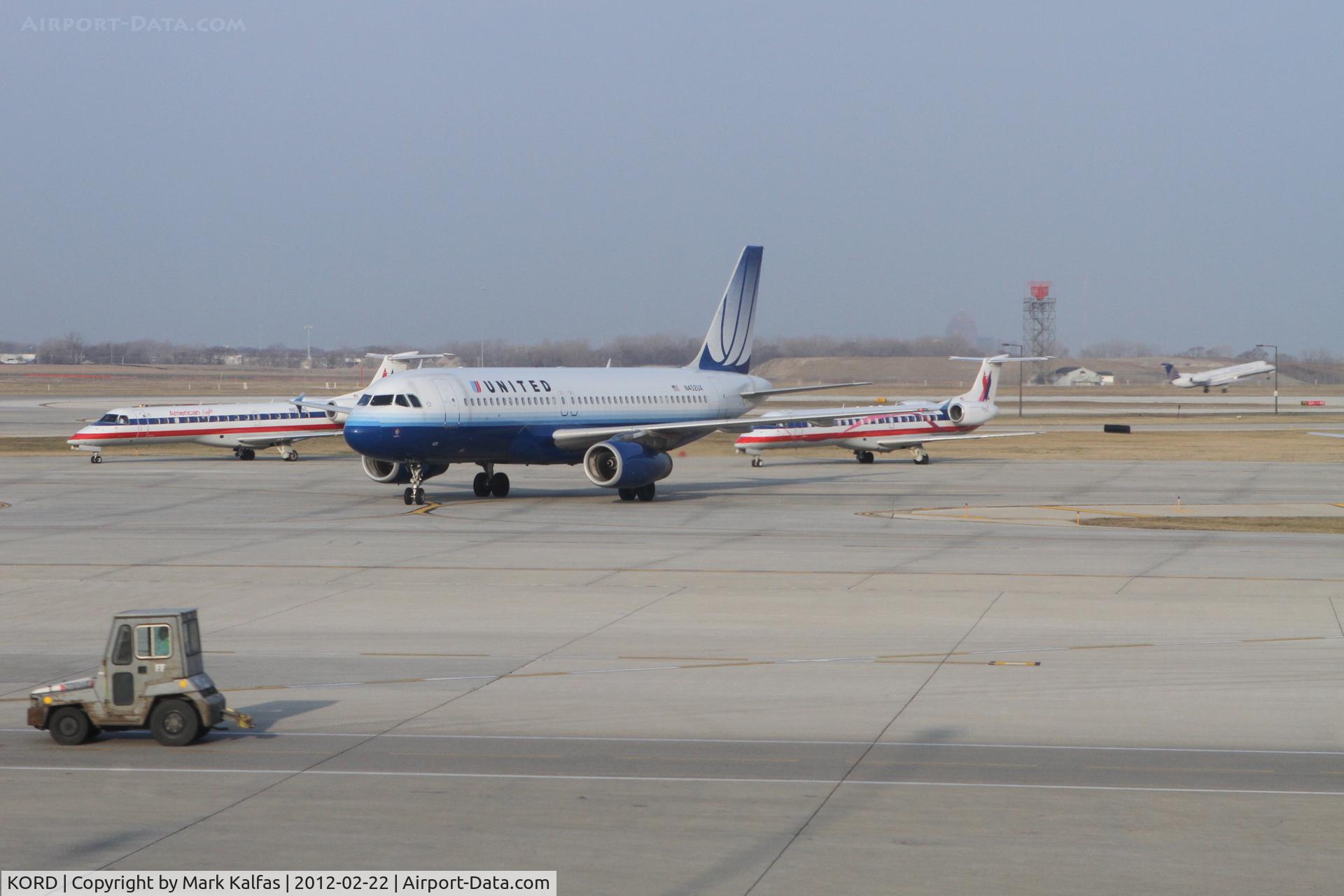 Chicago O'hare International Airport (ORD) - United Airlines Airbus A320 taxiing in on A4 with two American Eagle Embraer jets in the penalty box and a United Express  Embraer departing 32L in the background.