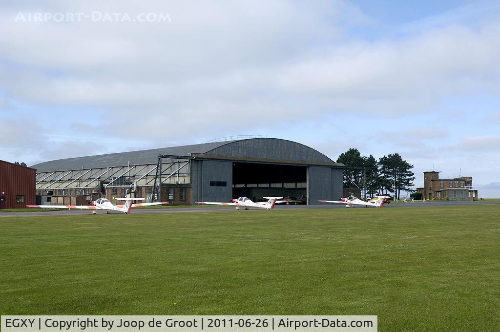 RAF Syerston Airport, Newark-on-Trent, England United Kingdom (EGXY) - Overview of the Air Cadets flightline. The old 1939 built J-type hangar is still in use, but the watchtower to the right is now replaced by a mobile caravan.