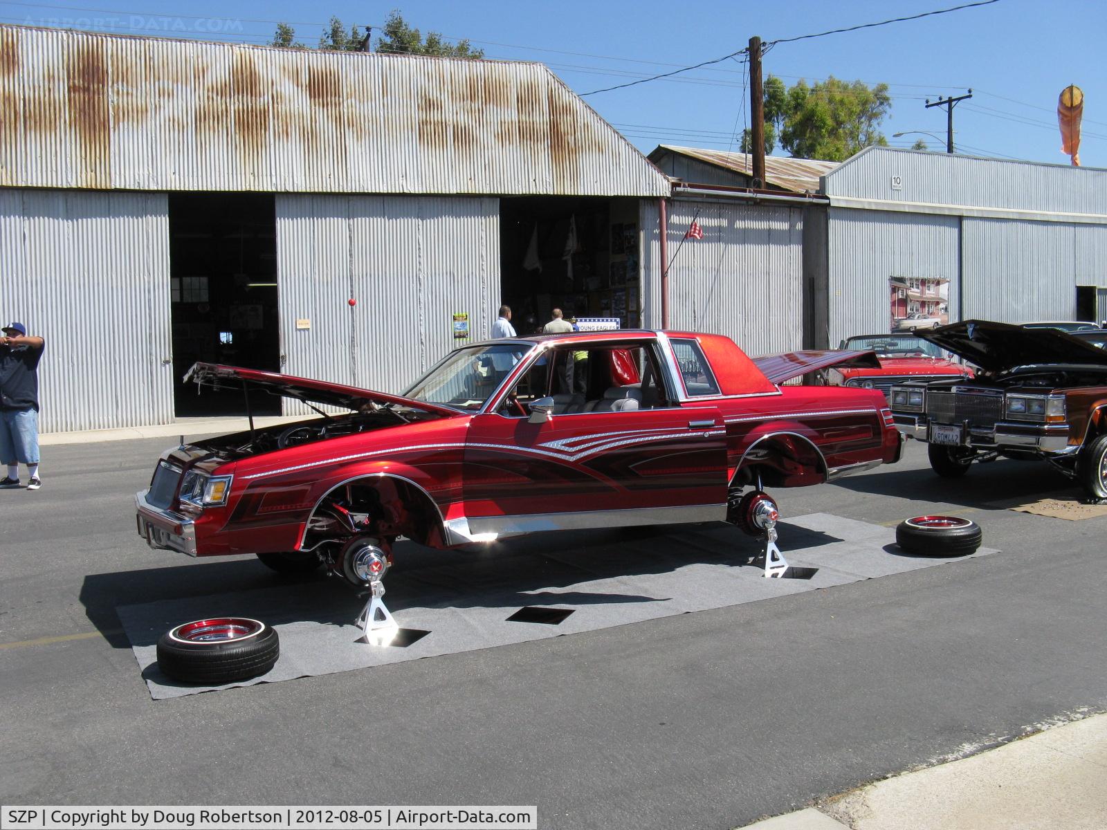 Santa Paula Airport (SZP) - First Sunday Aviation Museum of Santa Paula Open House & Fly-In invites car clubs-another hydraulic-jacked GM custom car on jacks to show off suspension, wheels  & hydraulics.