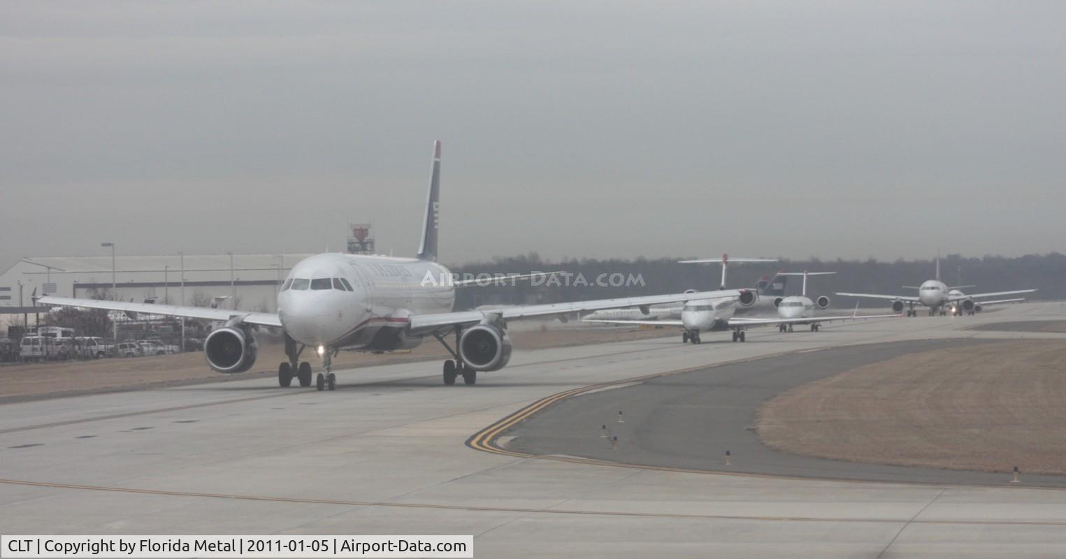 Charlotte/douglas International Airport (CLT) - Well it is January so it is a little hazy. However that was mainly from the Windows of my US Airways (Piedmont retro colors) A319 - Here is  a line up of planes waiting for us to take off