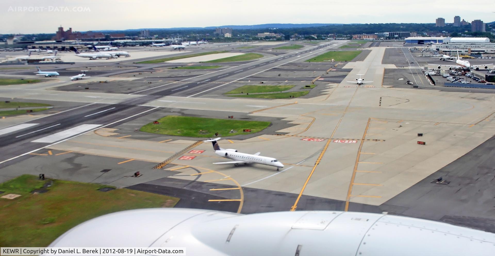 Newark Liberty International Airport (EWR) - We are just coming in over the northern end of Newark Airport, about to land on Runway 22L.  To the right is the northern freight terminal, used by Kalitta Air and DHL; to the left is Terminal C.  The shorter cross-runway, Runway 29 is in the middle.  A U