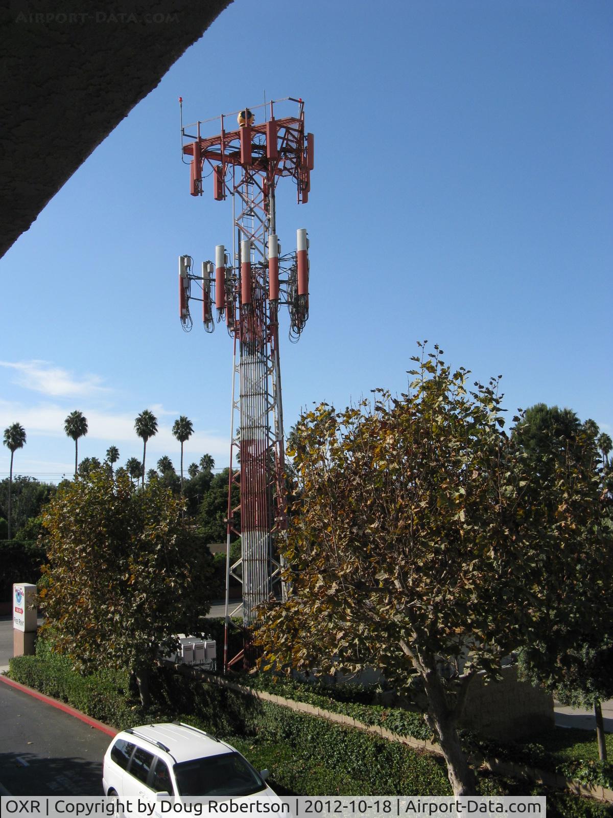 Oxnard Airport (OXR) - OXR's Airport Rotating Beacon (clear-green) with sector block to the OXR Air Traffic Control Tower, atop one of several antenna farms. Location: SE. Photo from off-airport. White-Red vertical antennas are cell phone repeaters.