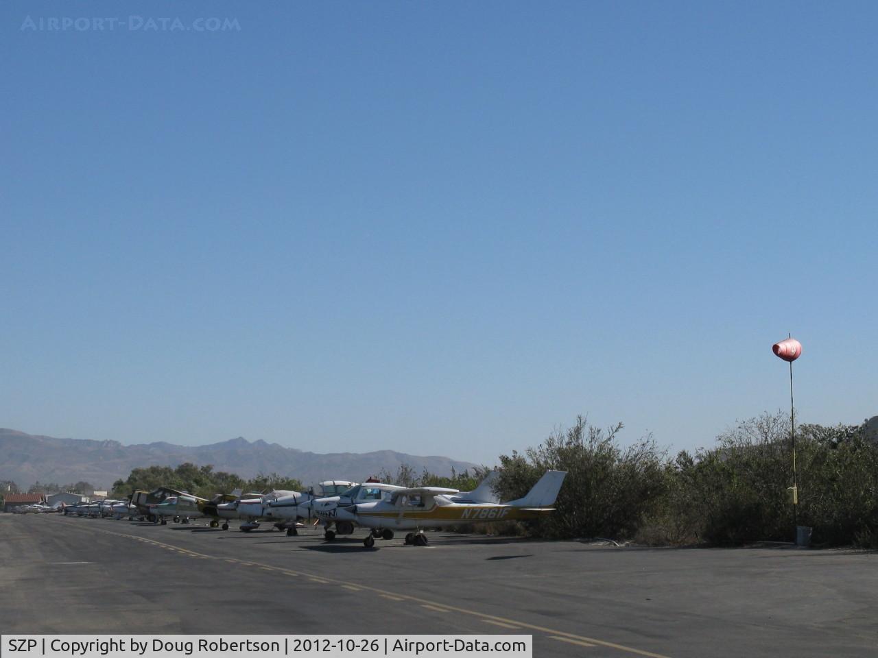 Santa Paula Airport (SZP) - Taut windsock Rwy 04 during strong Santana wind from E-SE. Riverbank tiedown aircraft behind. Thirty-five knot winds with gusts forecast.