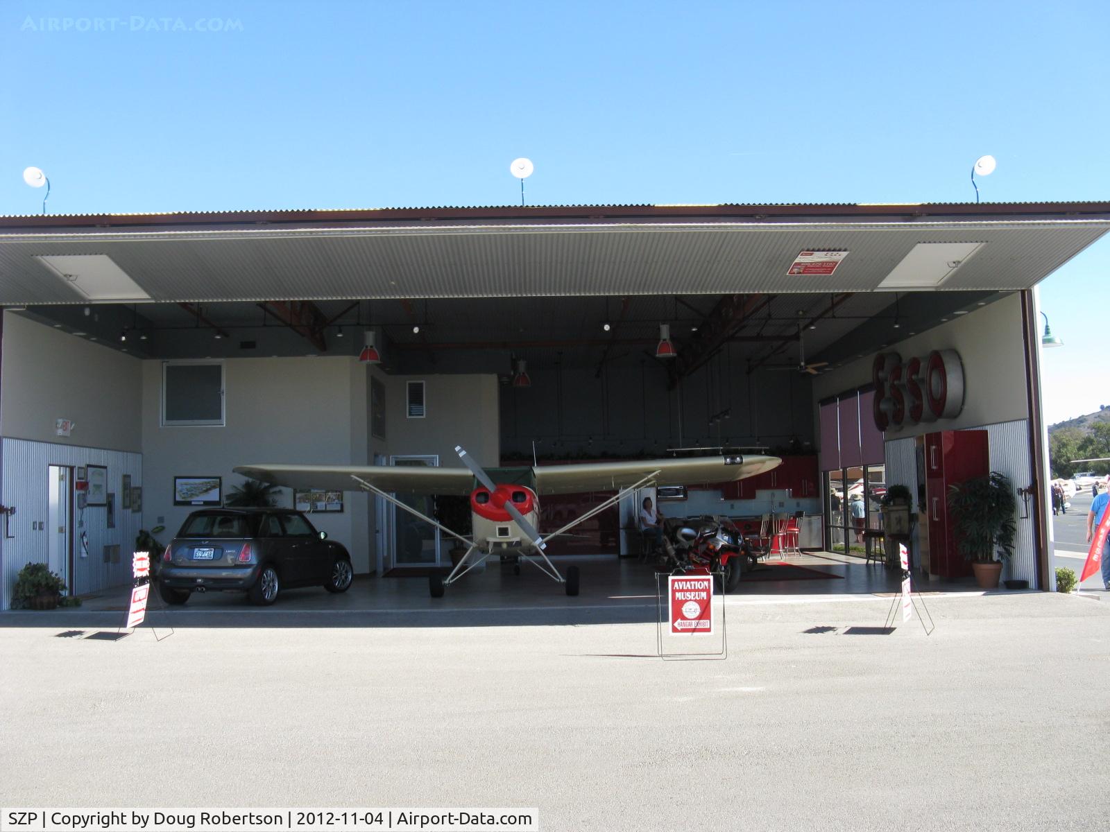 Santa Paula Airport (SZP) - Large Deluxe Hangar FOR SALE on corner of Curtiss taxiway and Museum taxiway. Prime midfield location near Fuel Dock. Bifold full-span door open.