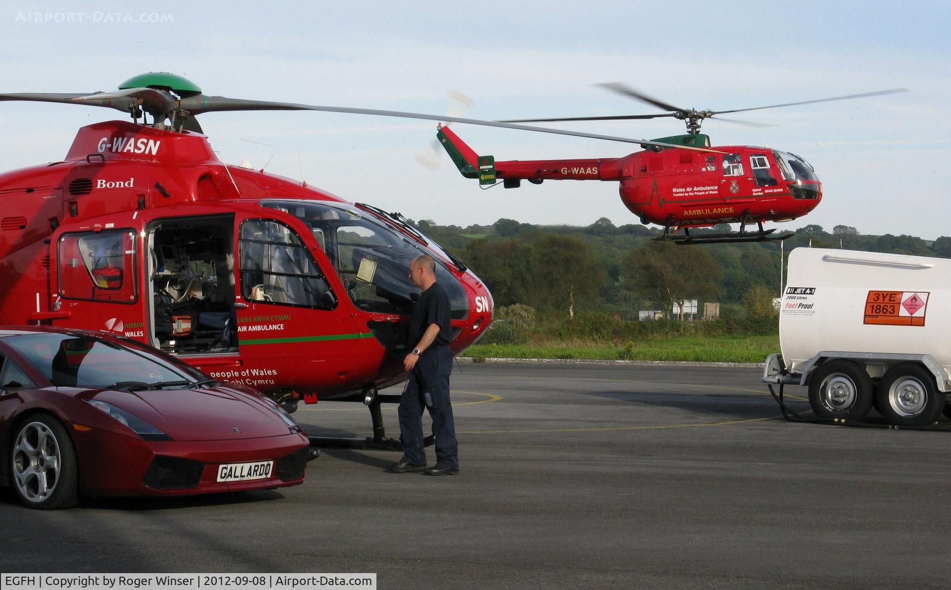 Swansea Airport, Swansea, Wales United Kingdom (EGFH) - Busy day at the Wales Air Ambulance base as the mid-Wales helicopter lands for fuel.