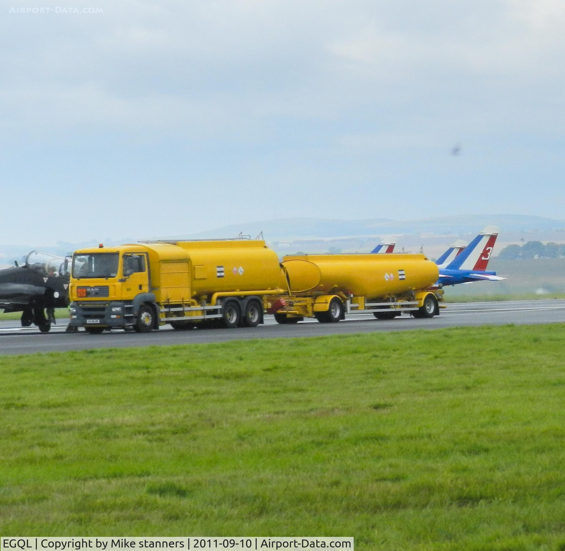RAF Leuchars Airport, Leuchars, Scotland United Kingdom (EGQL) - a fuel bowser arrives to refuel the red arrows while in the back ground 3 Patrouille de france Alphajets can be seen taking off from runway 09