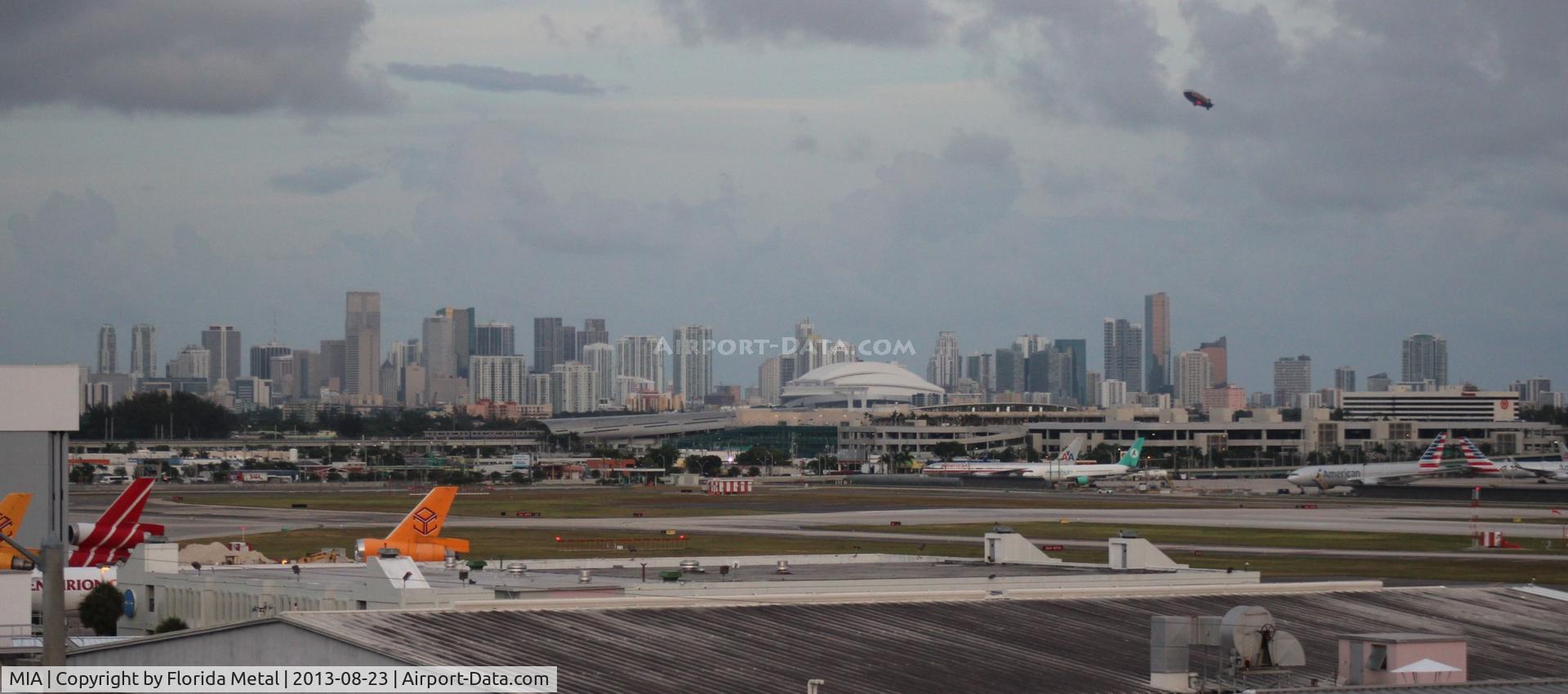Miami International Airport (MIA) - Downtown Miami seen from the 11th floor of the Comfort Inn with Miami Airport's northeast ramp area.  Goodyear Blimp flying over Downtown.  Marlin's stadium also seen