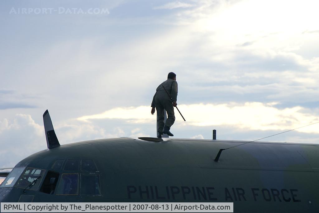 Lumbia Airport, Cagayan De Oro Philippines (RPML) - 107 - Check out the Flight Engineer walking on the Roof of this Herc to check Fuel Level in the Wingtanks with a wooden stick he is carrying with him.