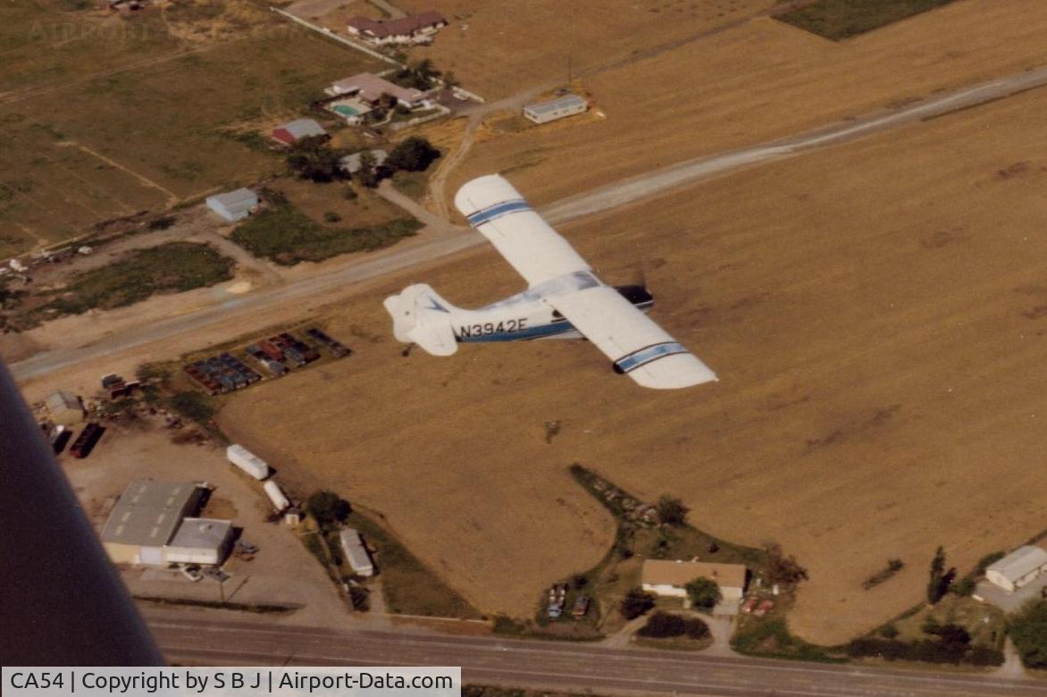 33 Strip Airport (CA54) - 42E flying over 33 Strip in 1987.It was closed around 2010 with a new airport several miles to the east being built. Road at bottom of picture is Hy 33 .