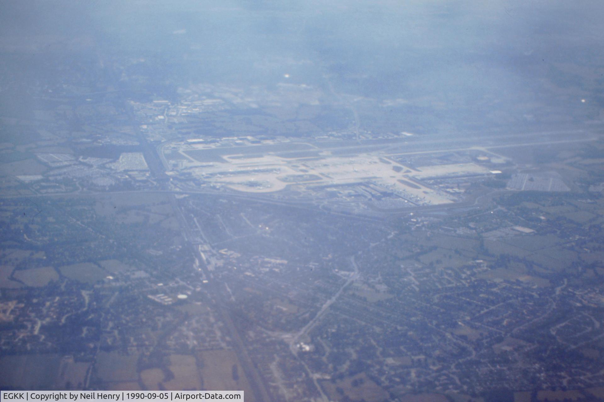 London Gatwick Airport, London, England United Kingdom (EGKK) - From scanned slide taken early September 1990 from departing NorthWest Airlines flight to MSP.  View shows airport from the north about 15k altitude and climbing.