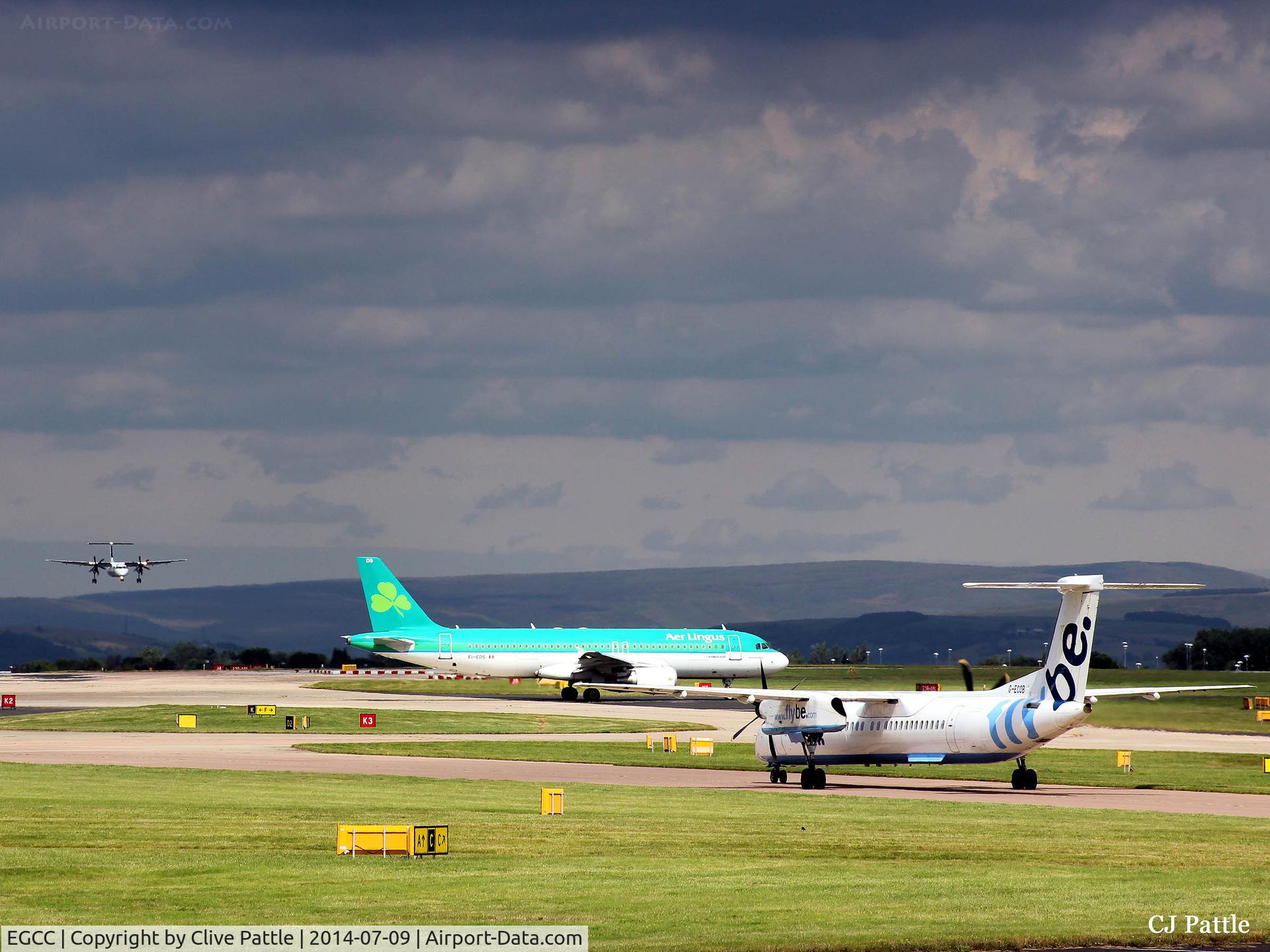 Manchester Airport, Manchester, England United Kingdom (EGCC) - Busy scene at Manchester EGCC with storm looming in the background.