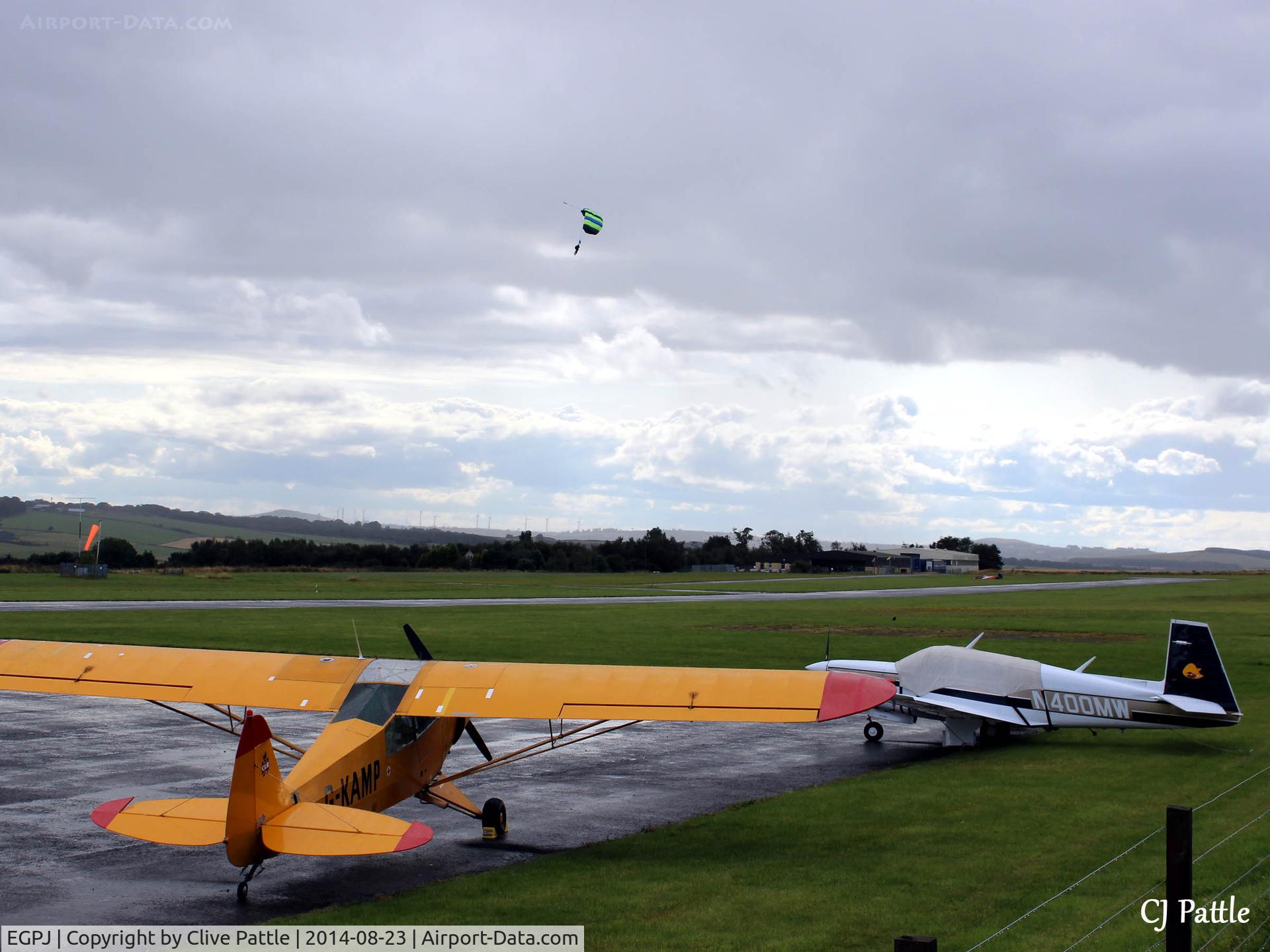 Fife Airport, Glenrothes, Scotland United Kingdom (EGPJ) - Airfield scene looking west, parked aircraft and skydiver landing in the background at Glenrothes EGPJ