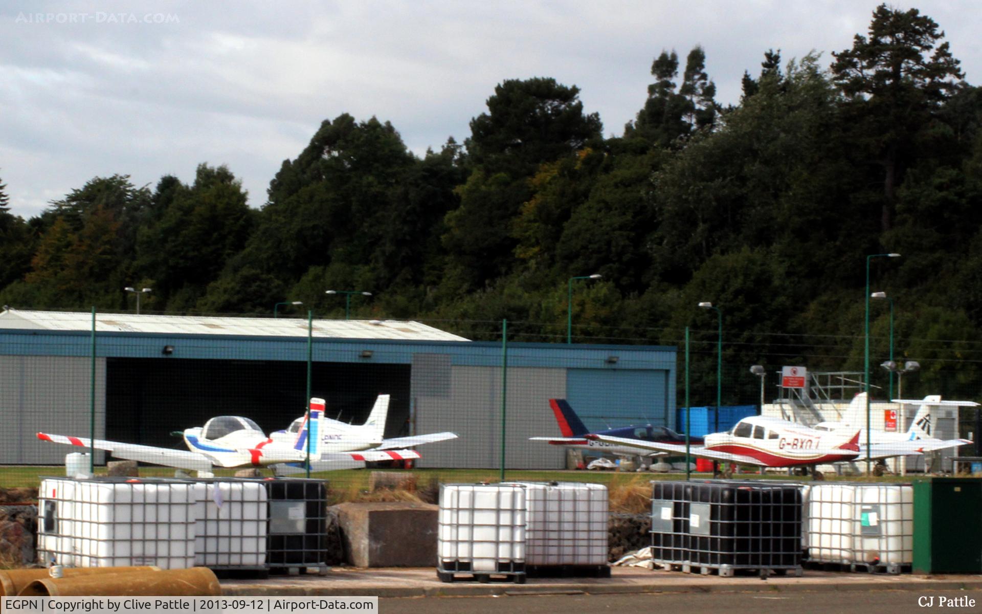 Dundee Airport, Dundee, Scotland United Kingdom (EGPN) - An unusual view of the GA area at Dundee Riverside airport, viewed through the fence.