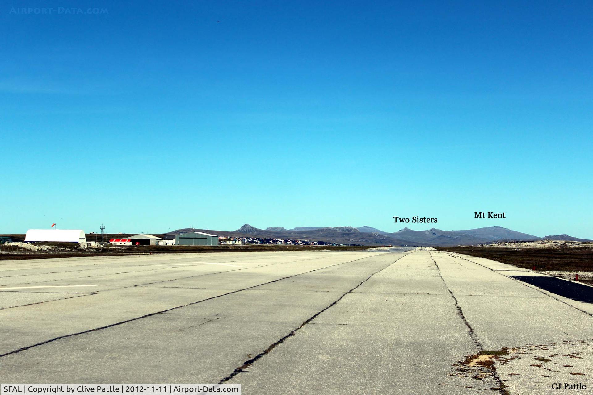 SFAL Airport - Lookg westwards down the runway at Port Stanley SFAL, with the airport terminal buildings on the left and the prominent mountains in the background, most of which featured heavily in the final battles in 1982.