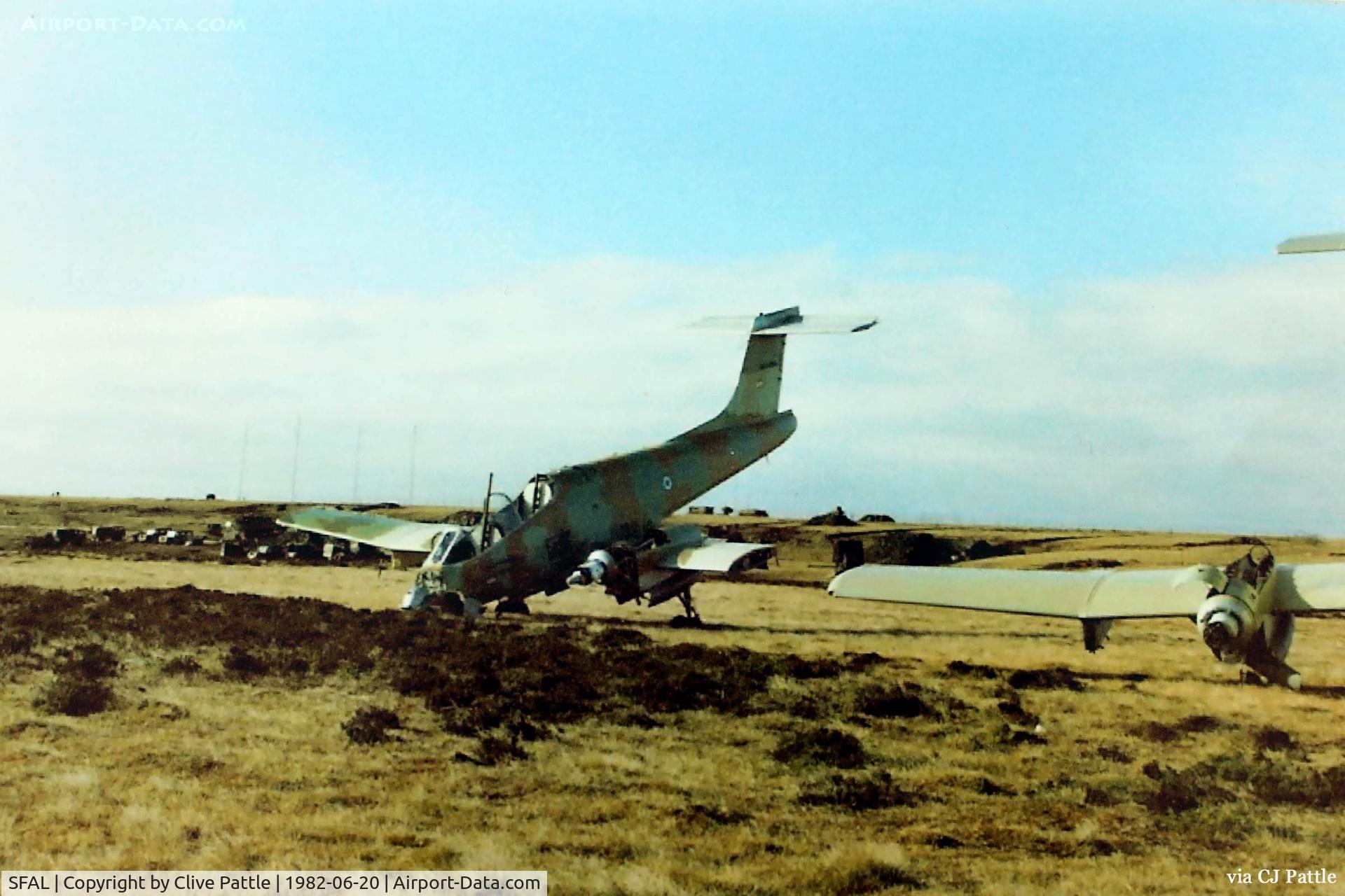 SFAL Airport - An historical view of Port Stanley SFAL immediately after the war in June 1982 showing a couple of wrecked Argentinian Pucara aircraft abandoned on the airfield. In the background some Argentinian Air Force equipment lies stockpiled