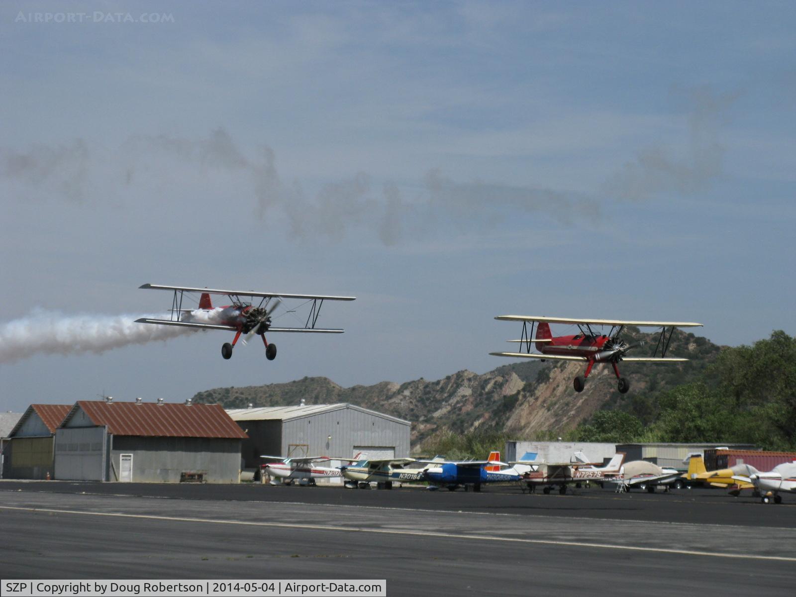 Santa Paula Airport (SZP) - Aviation Museum of Santa Paula 1st Sunday display day, N65124 with smoke and N66711 in echelon formation making fast low pass over Rwy 22, Bravo Zulu guys!