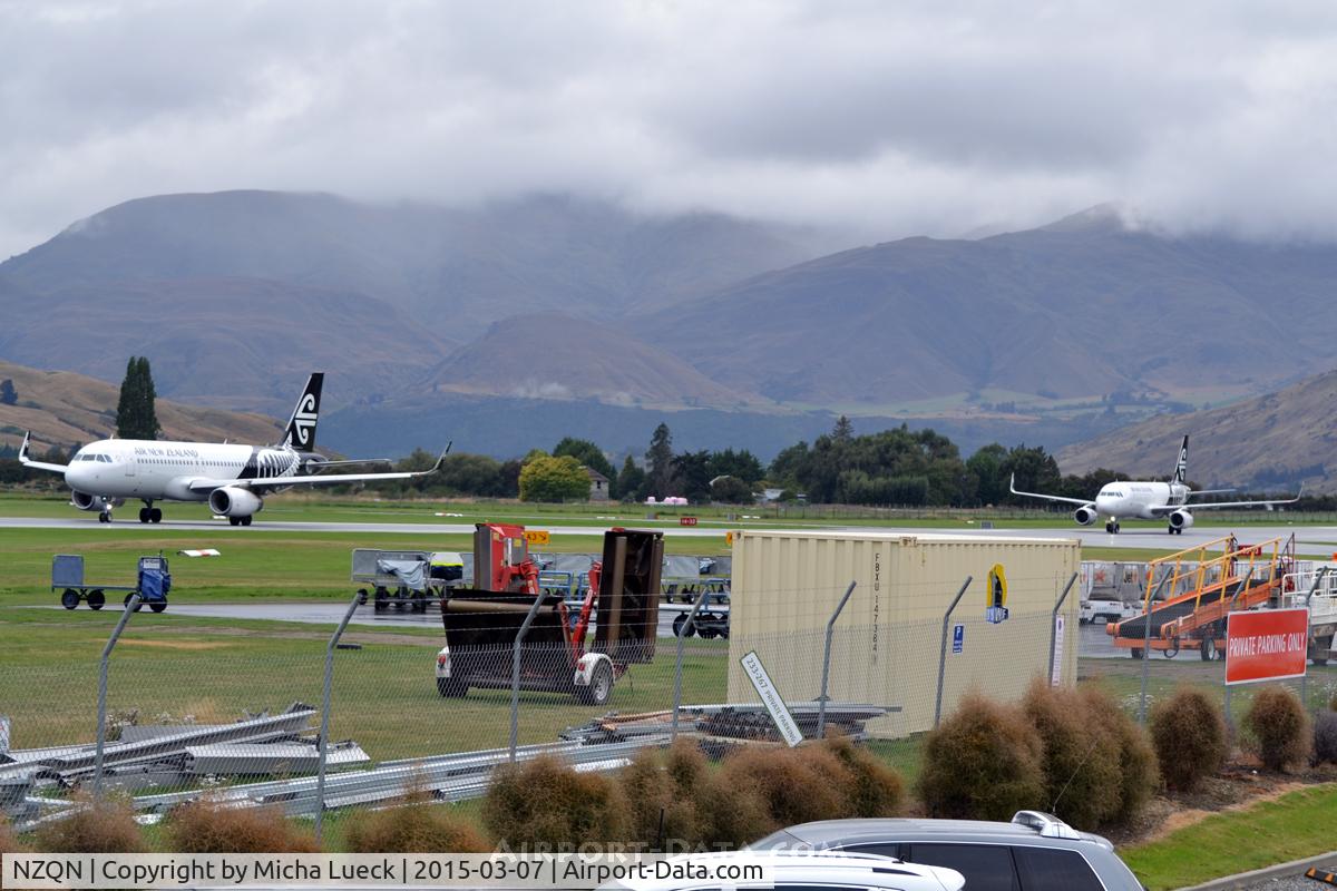 Queenstown Airport, Queenstown New Zealand (NZQN) - Two aircraft on the same active runway: The one on the left is taxing for take-off, and the one on the right just landed and is backtracking to the exit.