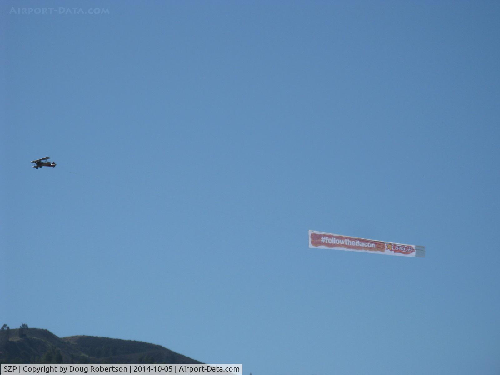 Santa Paula Airport (SZP) - N65124 Boeing Stearman towing FOLLOW THE BACON-Carl's Jr. advertising banner past South Mountain viewable by all of Santa Paula, CA.