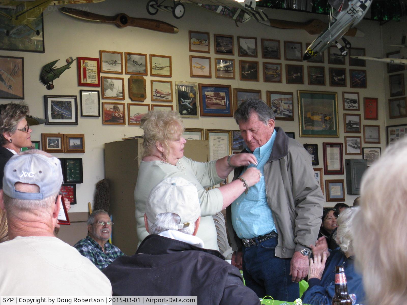 Santa Paula Airport (SZP) - Pat Quinn's Museum hangar on the occasion of his receiving the FAA Master Pilot Award for 50 years accident free-no violations flying. Arlys pinning her proud, well-deserved husband.