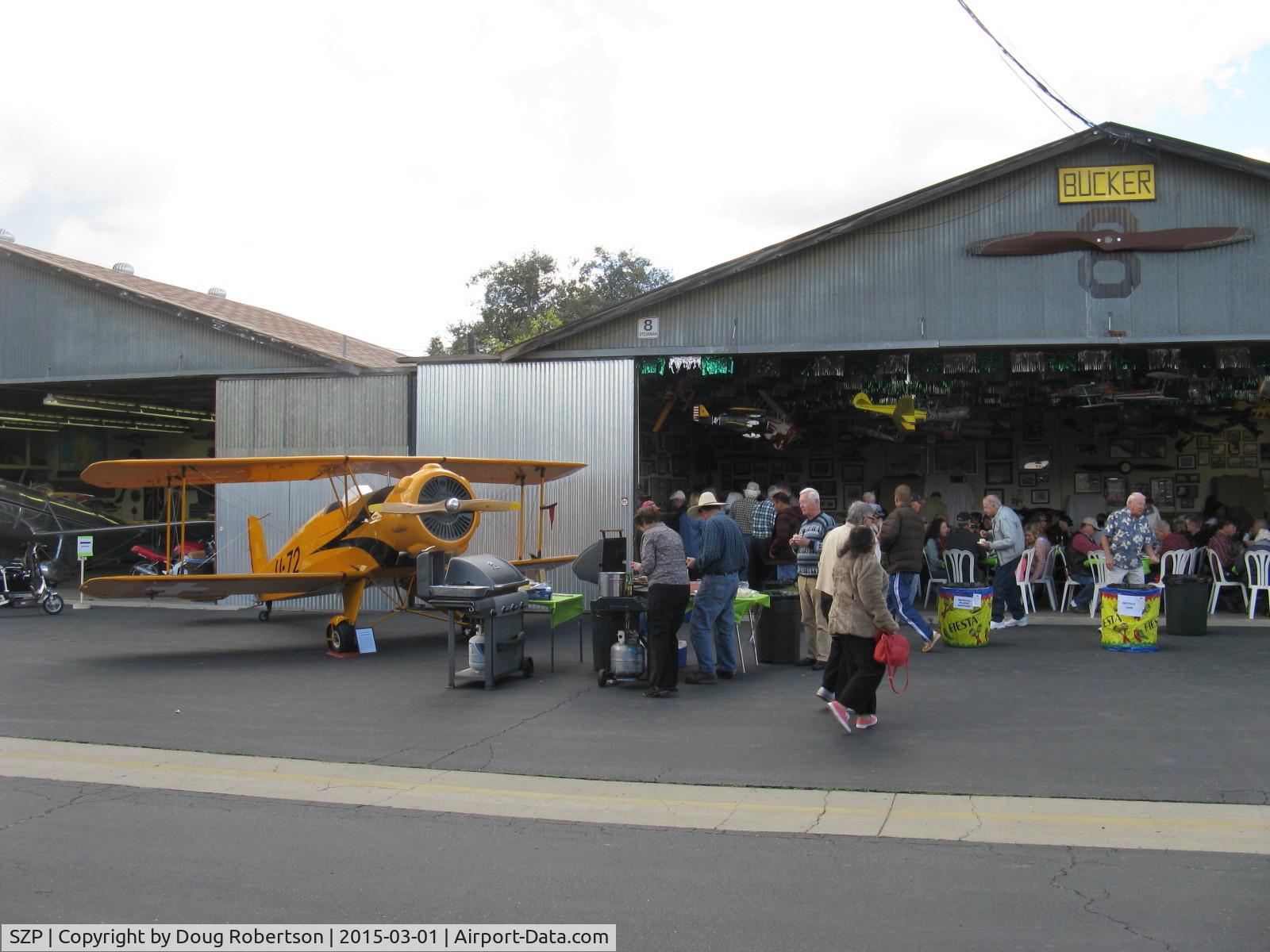 Santa Paula Airport (SZP) - The Pat Quinn Bucker Museum hangar with his Jungmeister 'Angel' flanking the hangar. Big barbecue luncheon with over 150 guests for his 50 year FAA Wright Brothers Master Pilot Award. Has owned 55 airplanes in 50 years!!!
