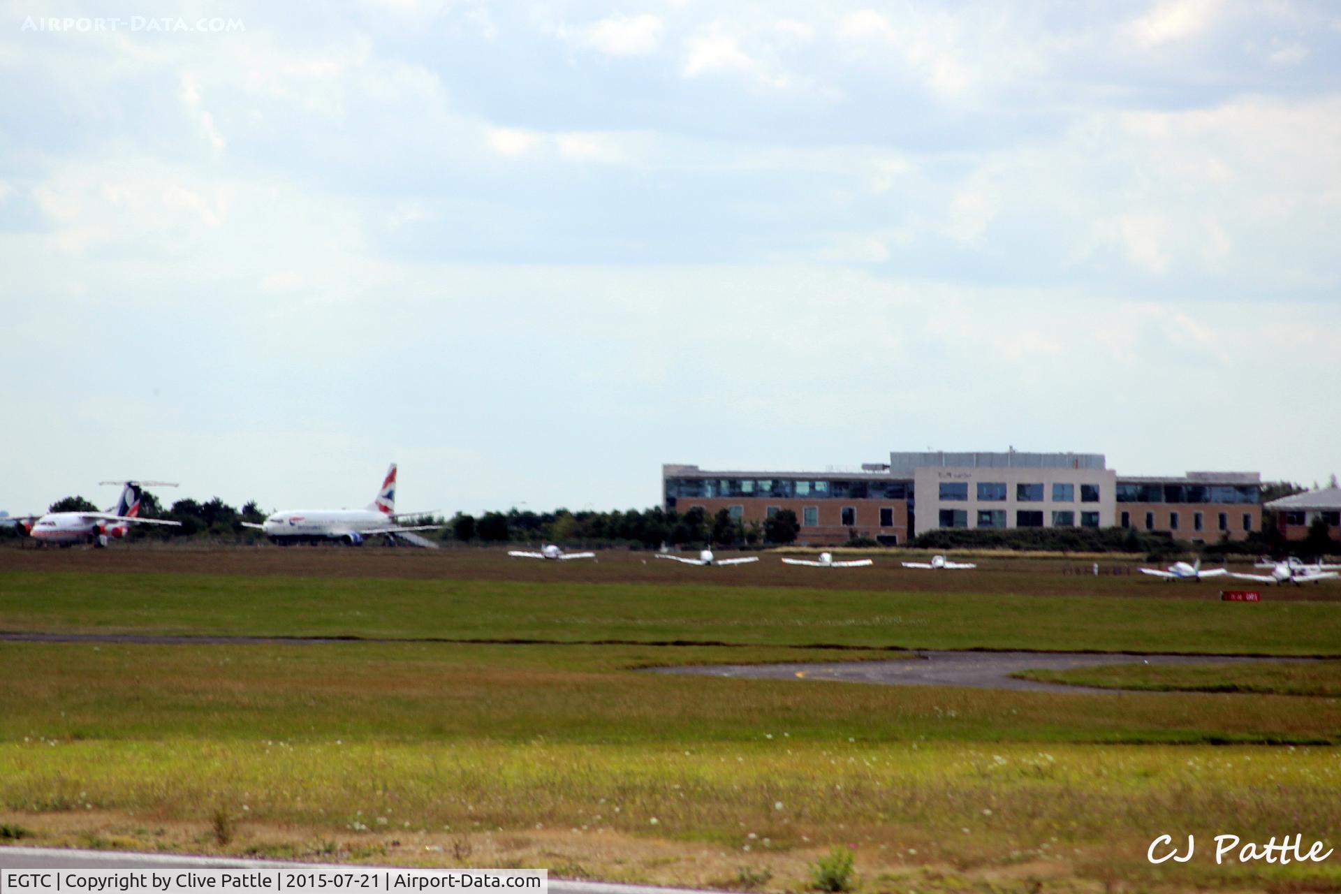 Cranfield Airport, Cranfield, England United Kingdom (EGTC) - Airport and Cranfield University buildings viewed from the runway at Cranfield EGTC. On the left are the two stored airliner instructional airframes, a BAe 146 and a B737.