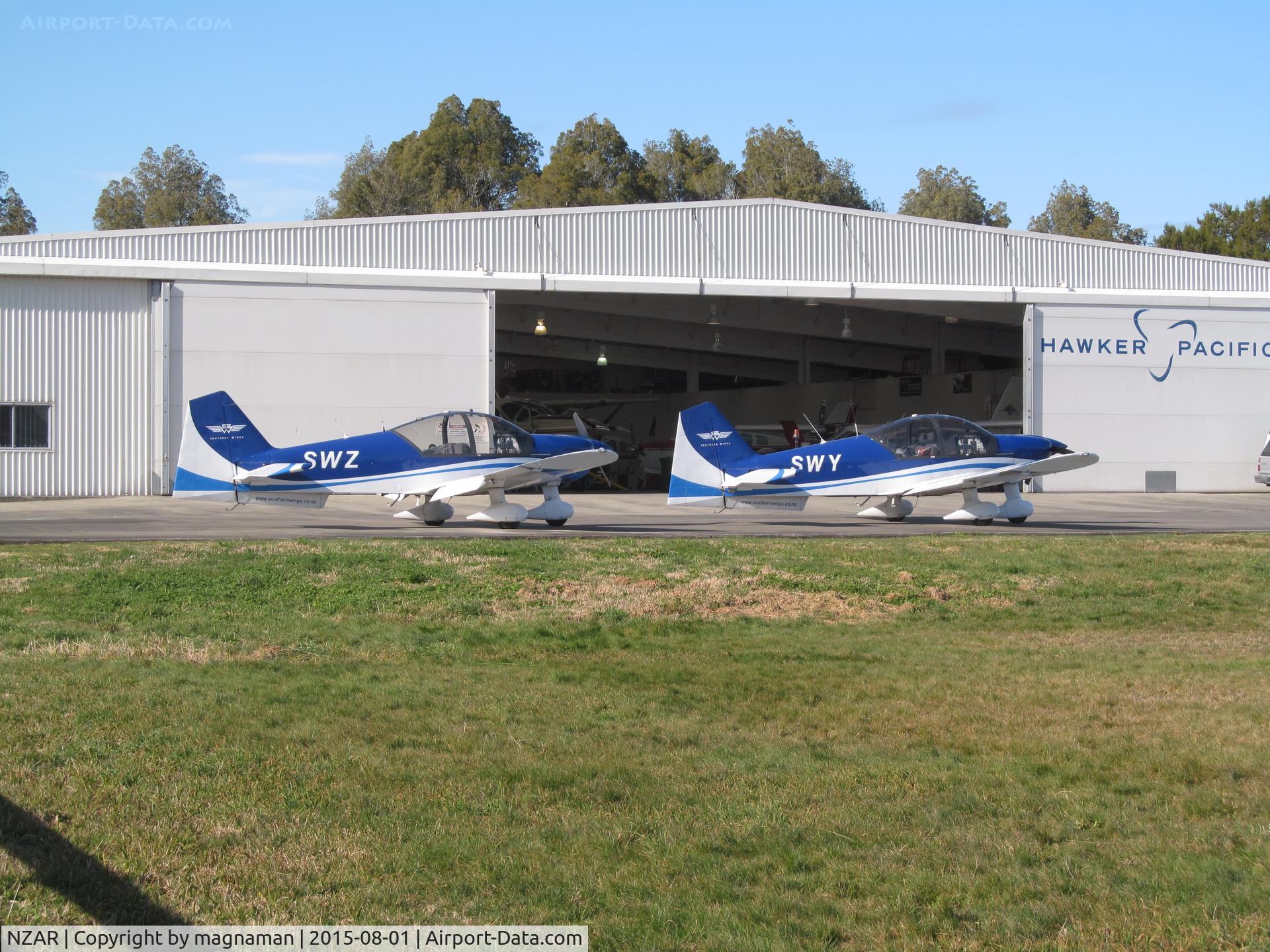 Ardmore Airport, Auckland New Zealand (NZAR) - Hawker Pacific Hangar to east end of airfield - always something of interest inside. Today two flying club alphas outside (SWY and SWZ) with recent C208 US import inside - now ZK-SDB