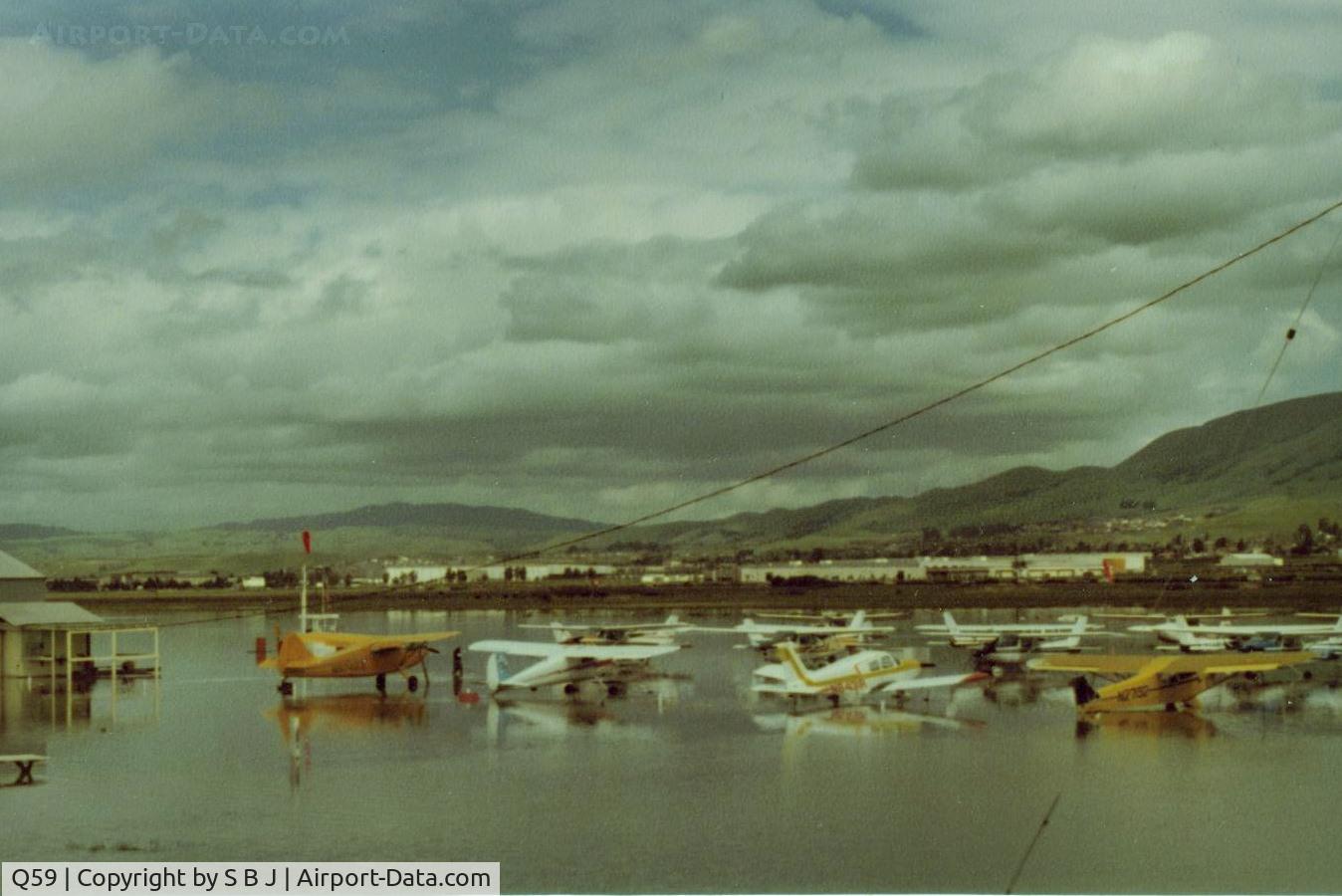 Q59 Airport - Fremont airport,Calif during one of its many floods and Carl seen in front of his yellow Stinson doing everything he could (raised plane etc) to protect his pride & joy.Few owners I knew cared more for their planes then Carl did.View is NE.