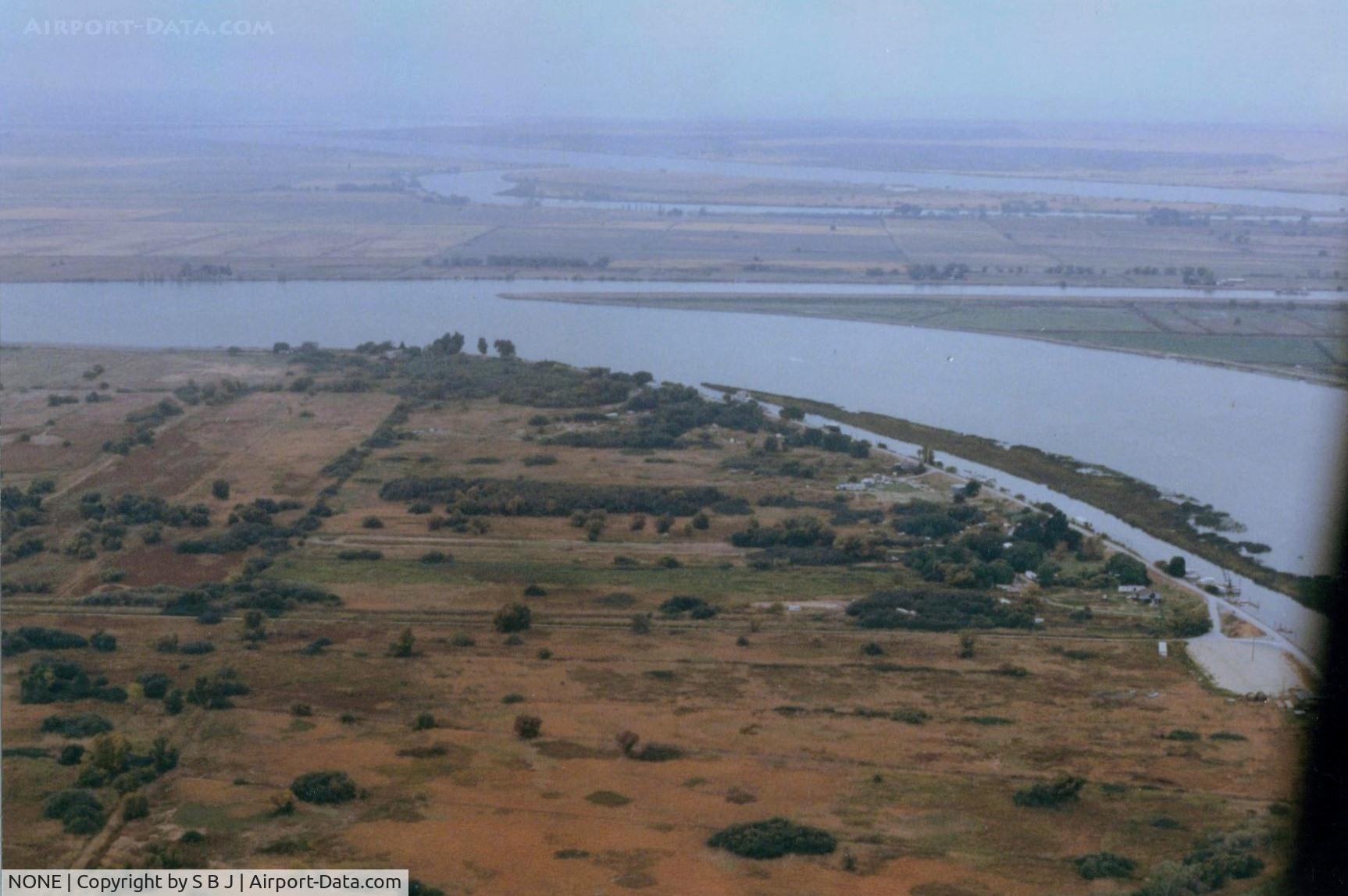 NONE Airport - Bob Ried  strip (private) near Rio Vista,Ca. It is seen in the middle of pic in 1973.It is where I learned that a 65 Tcraft does not get off like a 150 Cub due to short strip and high grass.Very near a NTSB statistic that day!! View is west.