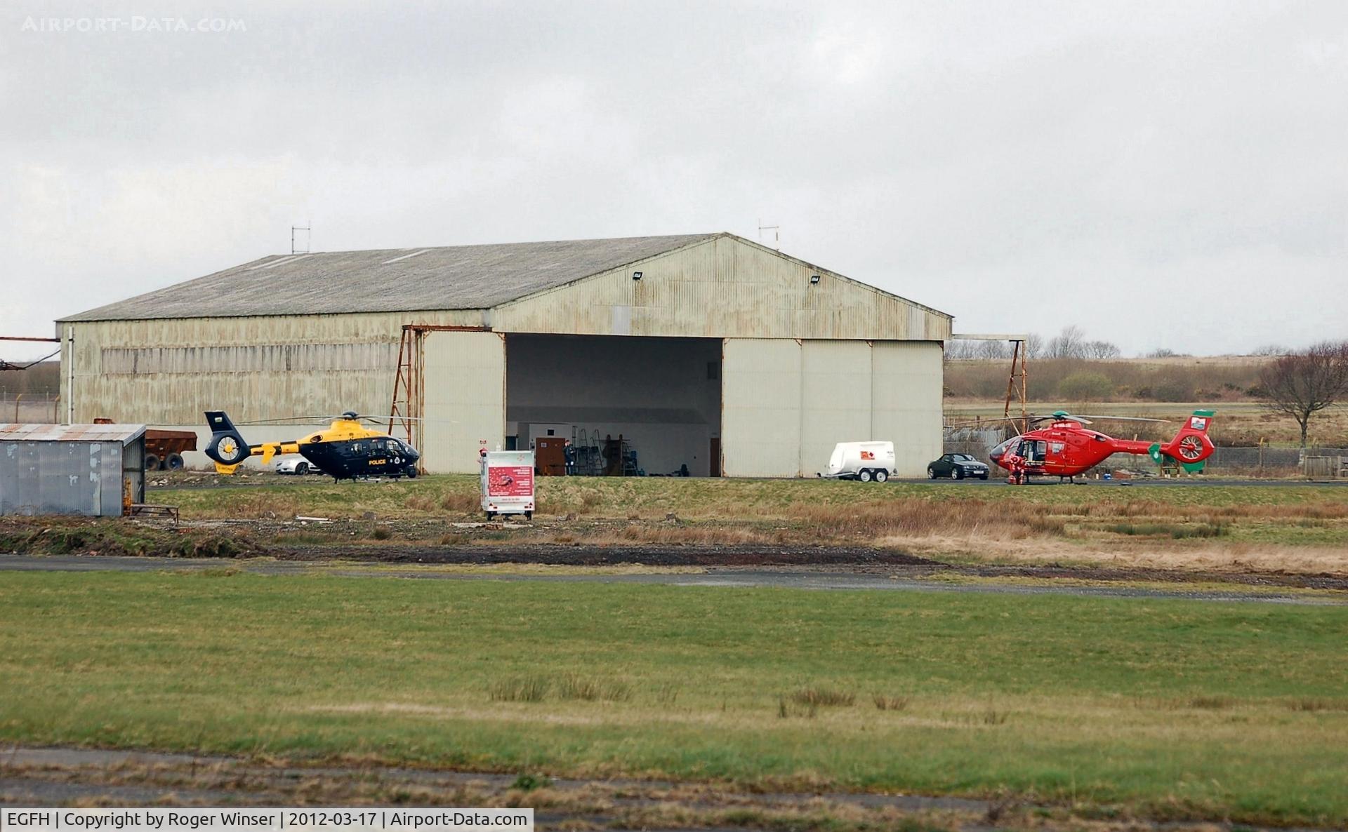 Swansea Airport, Swansea, Wales United Kingdom (EGFH) - Emergency services (police and air ambulance) helicopters at the Wales Air Ambulance base in Hangar 1.