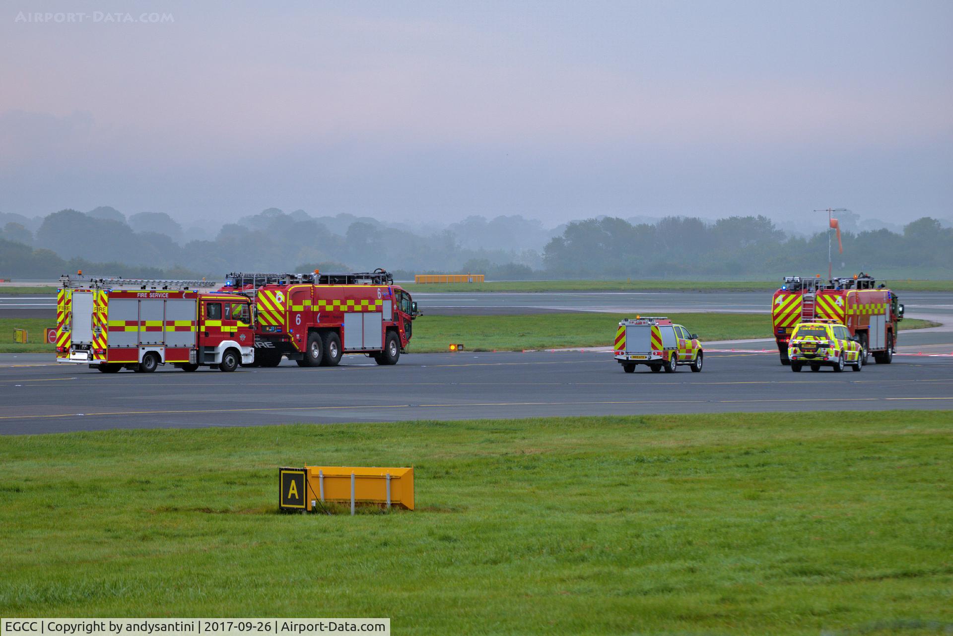 Manchester Airport, Manchester, England United Kingdom (EGCC) - man airport fire trucks waiting to cross runway 23R for 23L 