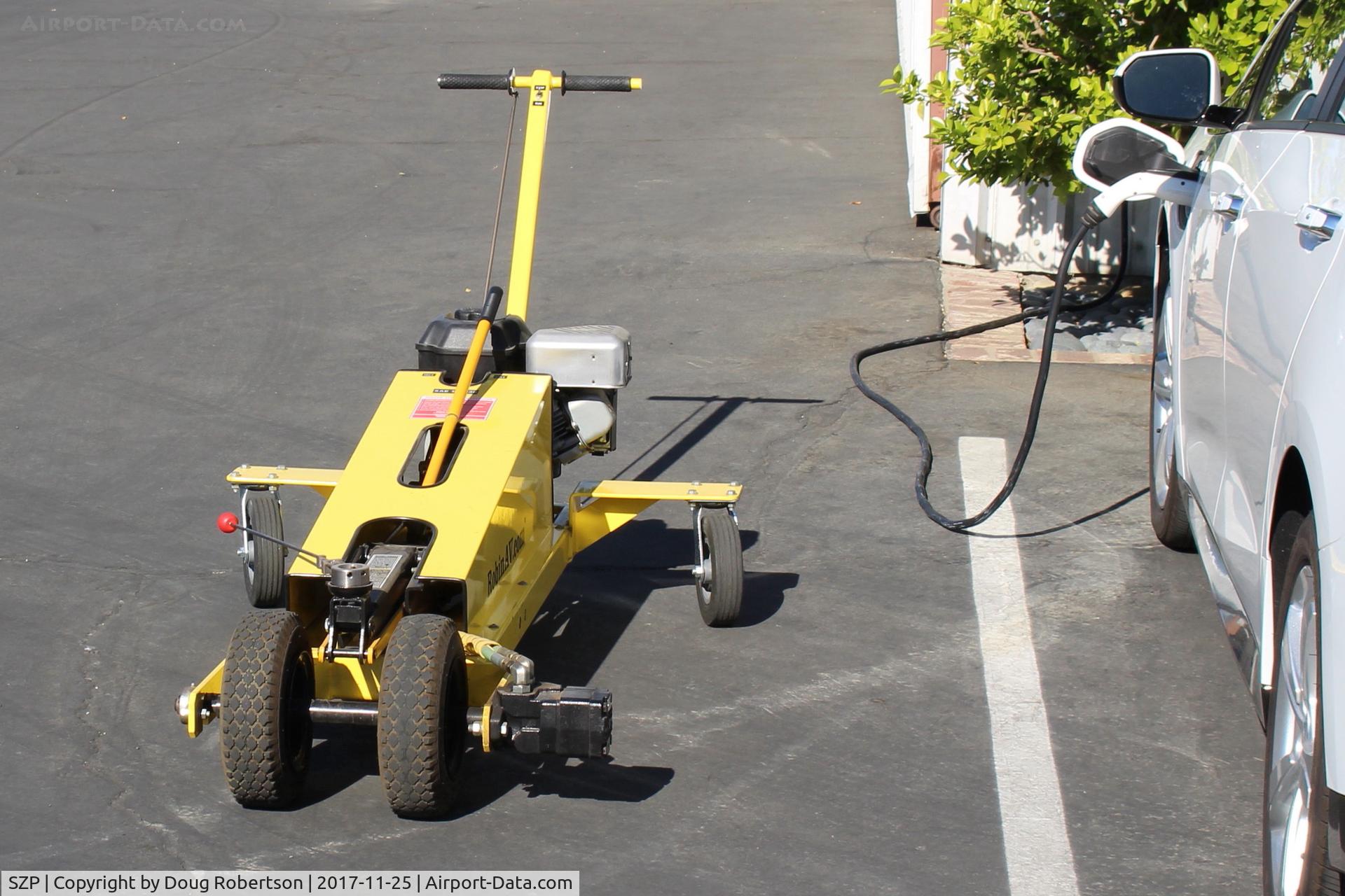 Santa Paula Airport (SZP) - This powered dolly moves a Robinson R44 helicopter in and out of its SZP hangar. Dual handle is for steering.