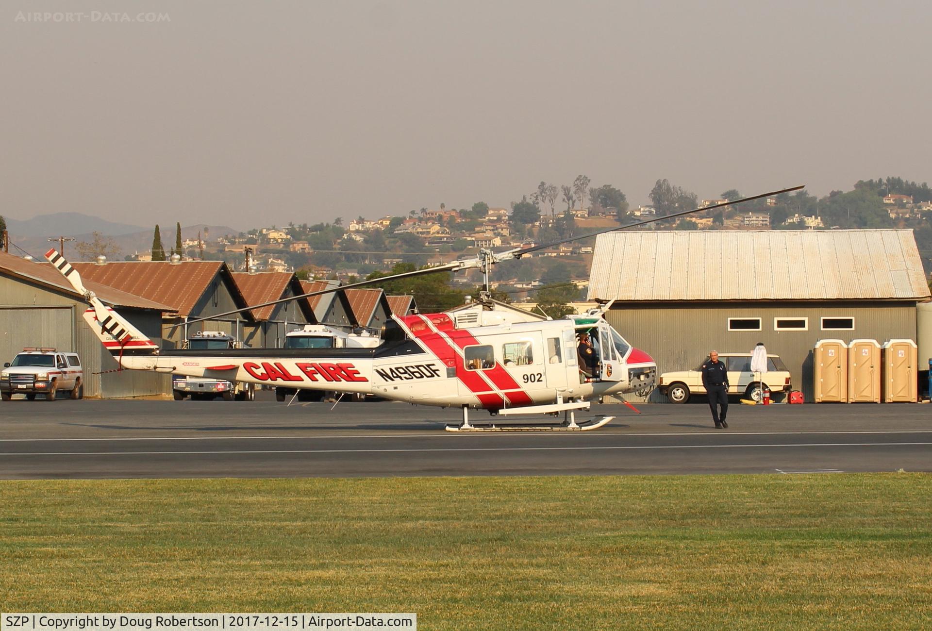 Santa Paula Airport (SZP) - N496DF 1969 Bell EH-1H IROQUOIS, (CAL-FIRE 902) Government USDA FOREST SERVICE, boarding for another sortie, Thomas Fire, at SZP FireBase. Note smoky sky.