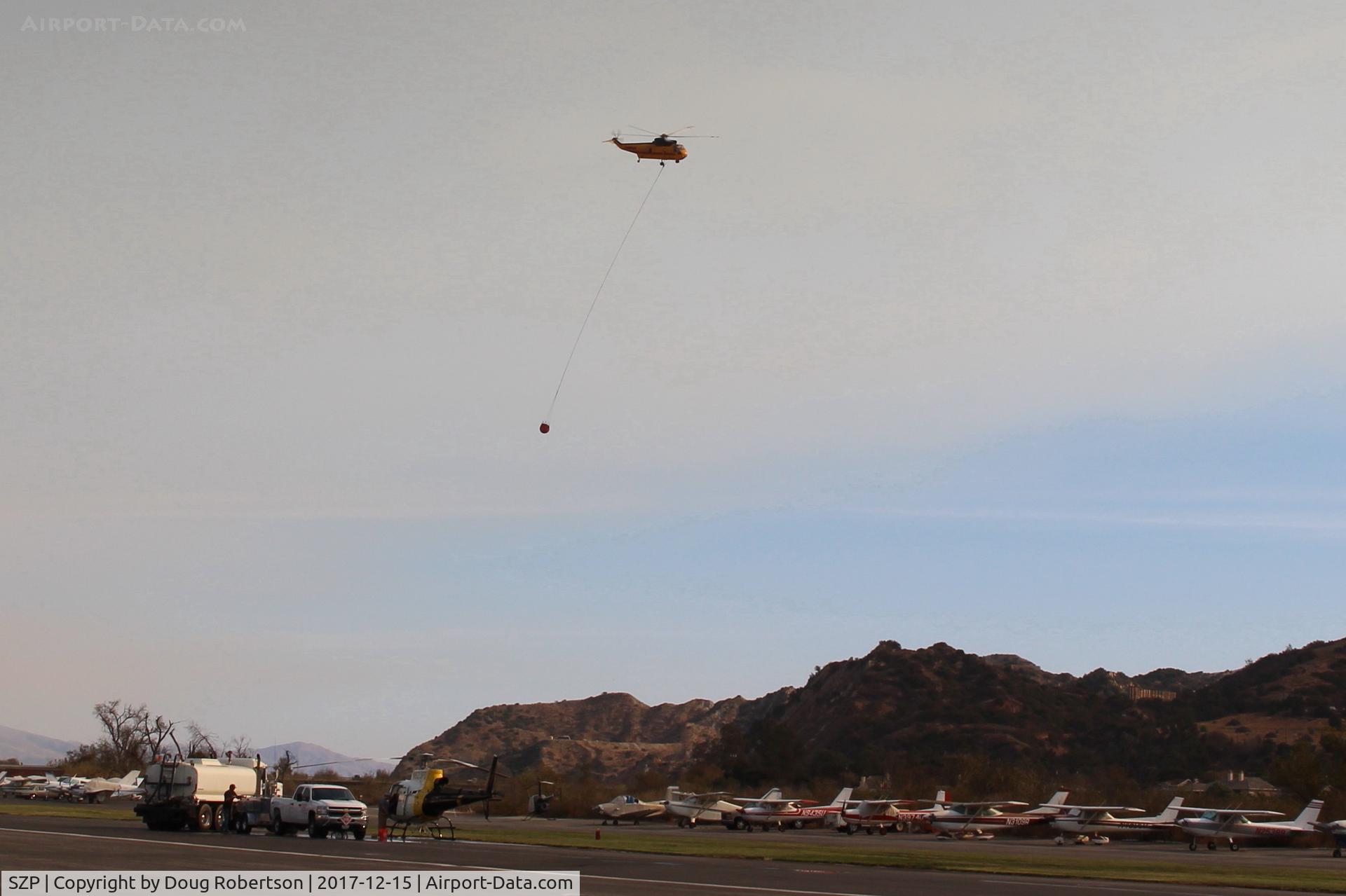 Santa Paula Airport (SZP) - CROMAN helicopter with PHOS-CHEK sling load departing SZP FireBase, note smoky sky