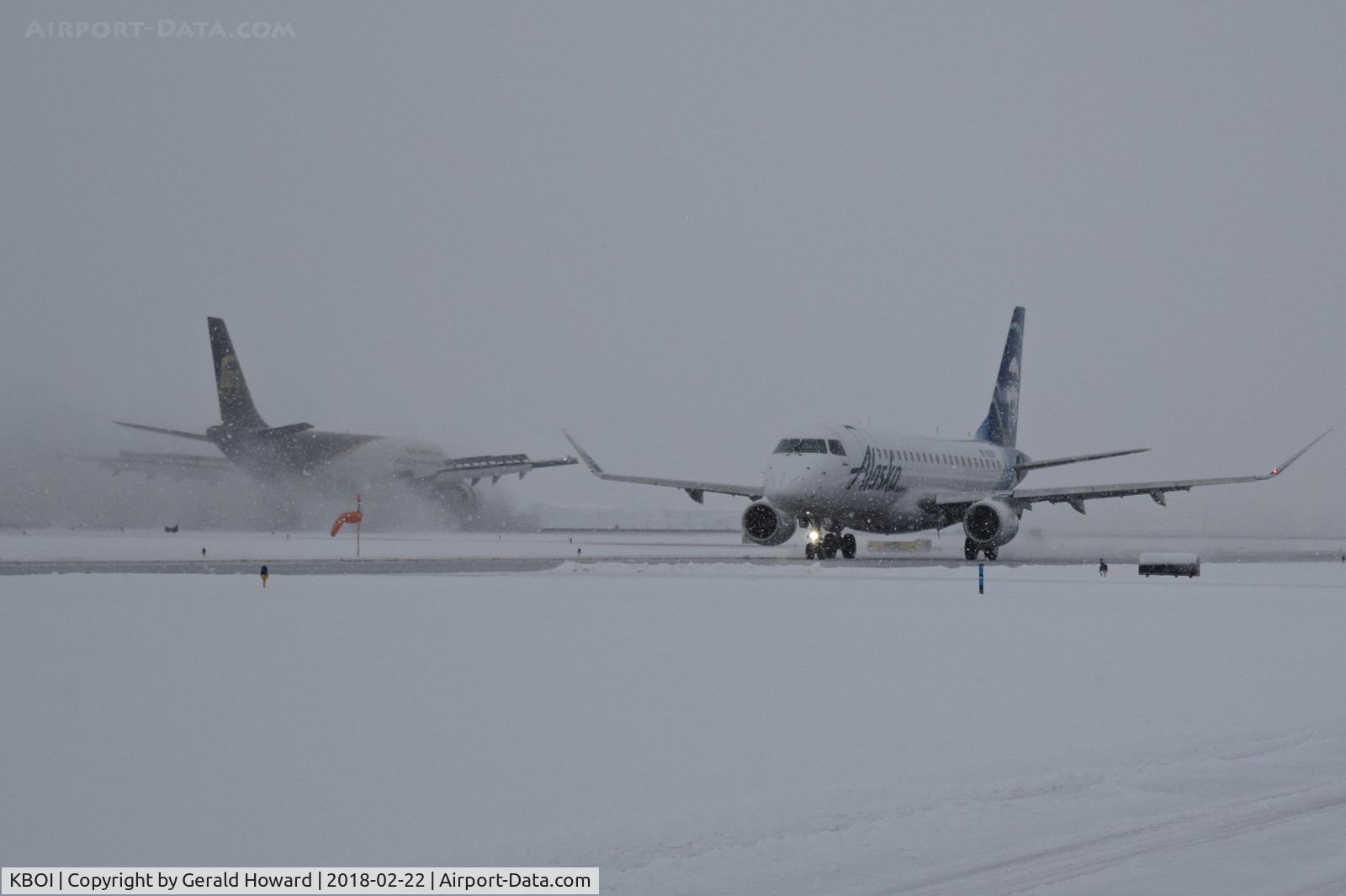 Boise Air Terminal/gowen Fld Airport (BOI) - Alaska taxiing on Alpha while UPS slows on a snow covered runway.