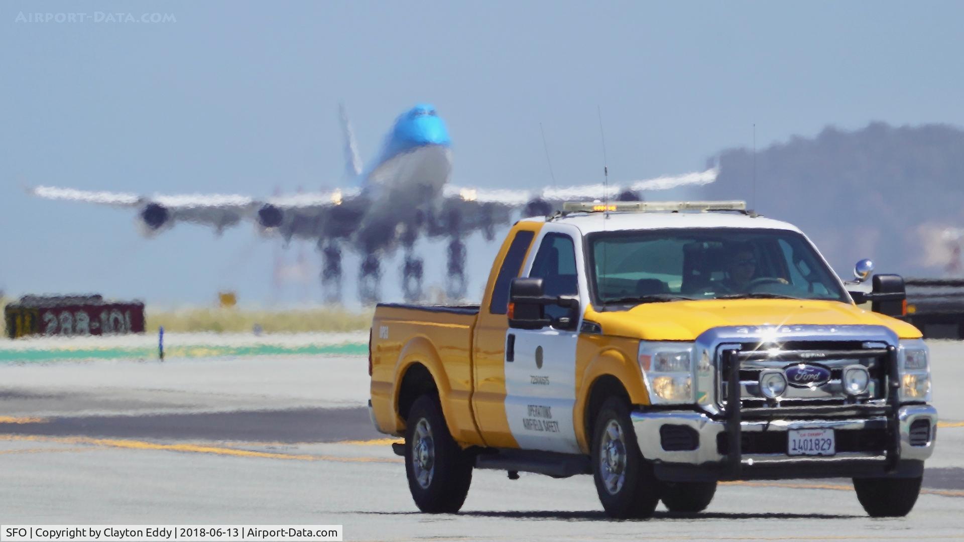 San Francisco International Airport (SFO) - Safety truck with KLM 747 PH-BFD departing the runway. at SFO 2018.