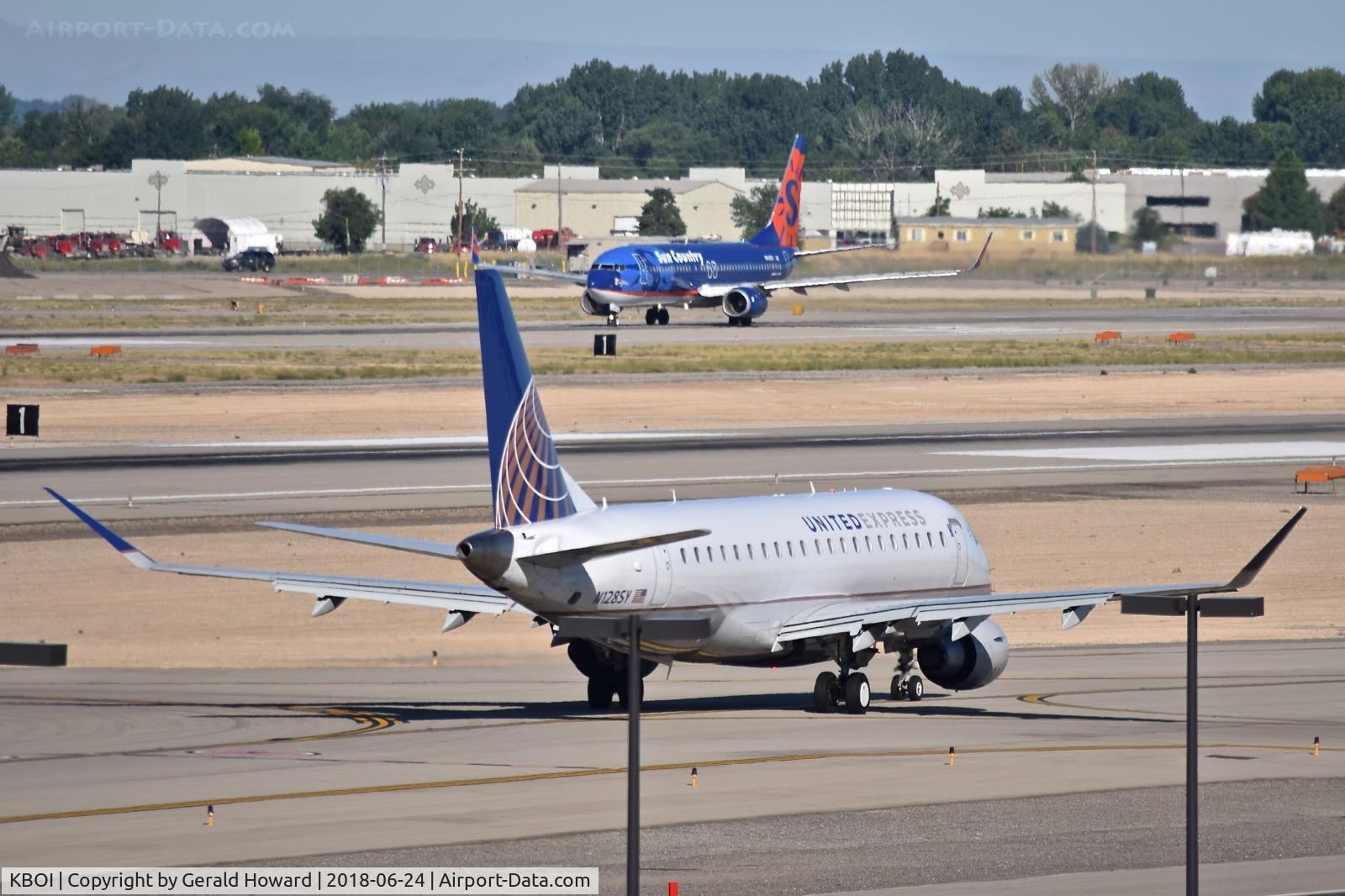 Boise Air Terminal/gowen Fld Airport (BOI) - United Express taxies out for RWY 10L while Sun Country takes off on RWY 10R.