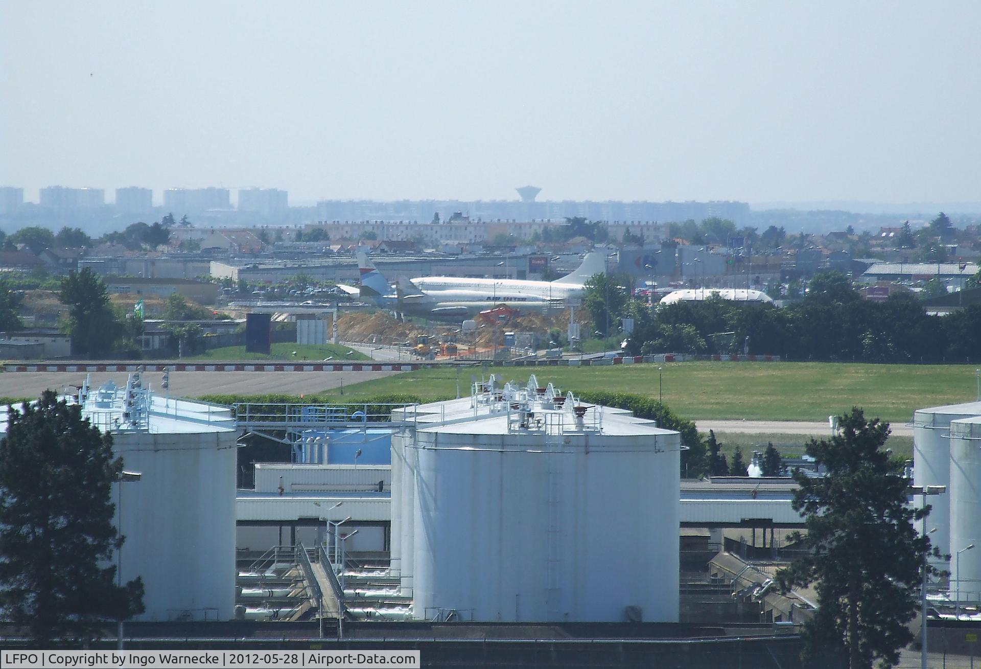 Paris Orly Airport, Orly (near Paris) France (LFPO) - storage tanks at Paris-Orly airport, in the background the aircraft of Athis-Mons aviation museum (Concorde, Mercure and Caravelle)