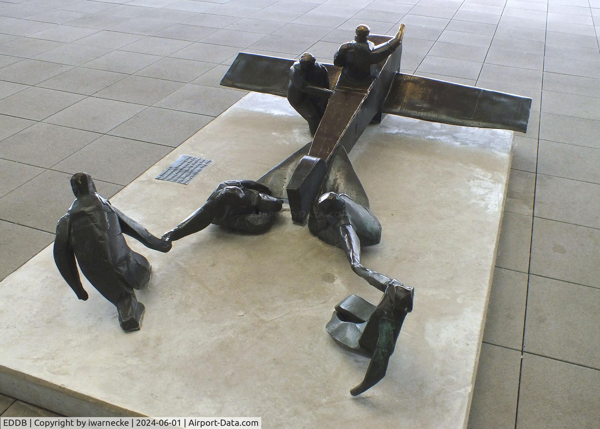 Berlin Brandenburg International Airport, Berlin Germany (EDDB) - sculpture 'Vor dem Start in Calais zum Europarundflug 1911 wartet die Mannschaft auf ein Zeichen des Piloten, das Flugzeug loszulassen' (at the take off in Calais 1911 the crew awaits a signal of the pilot to let go) 1983 by K. Biederbick at BER airport