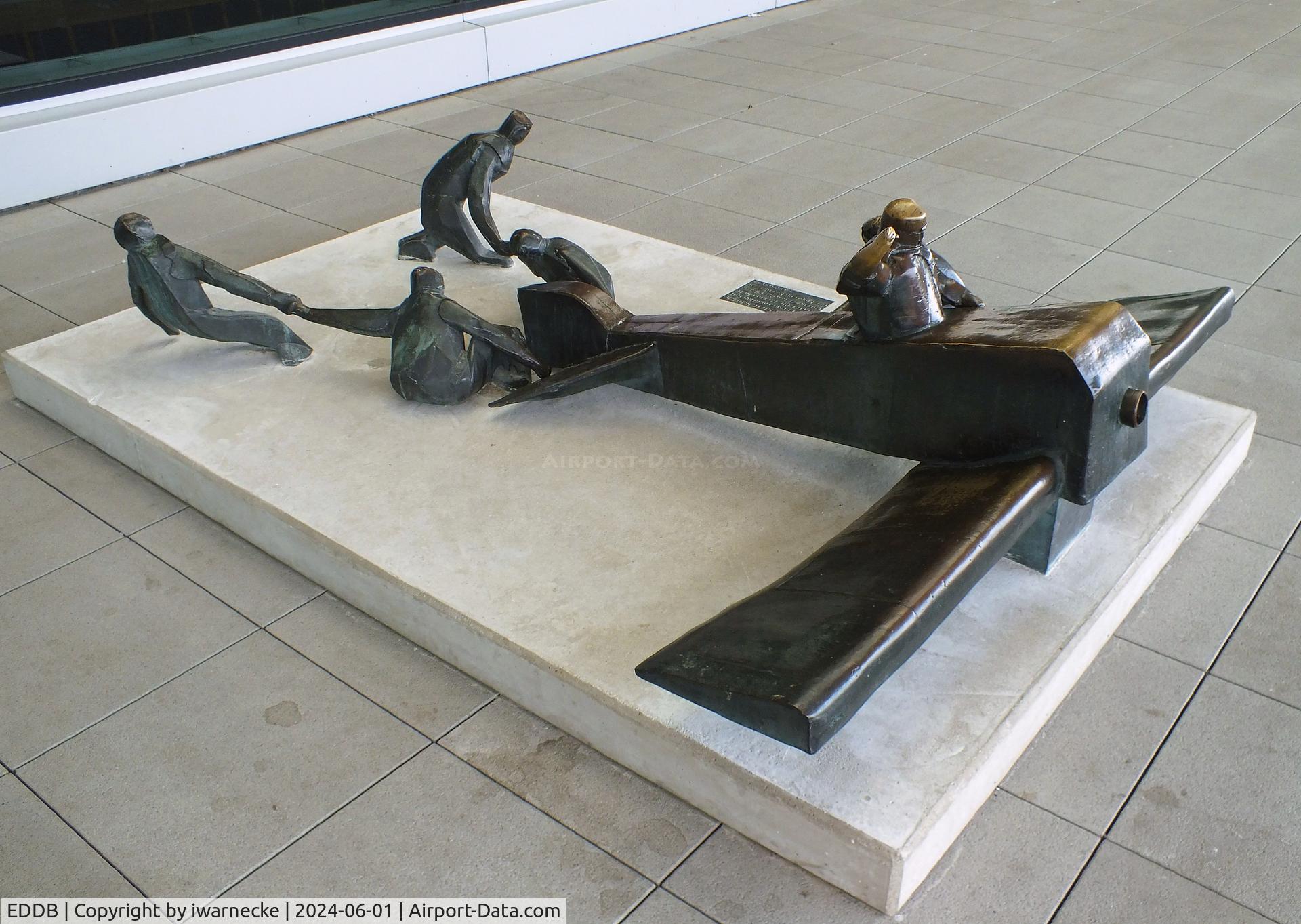 Berlin Brandenburg International Airport, Berlin Germany (EDDB) - sculpture 'Vor dem Start in Calais zum Europarundflug 1911 wartet die Mannschaft auf ein Zeichen des Piloten, das Flugzeug loszulassen' (at the take off in Calais 1911 the crew awaits a signal of the pilot to let go) 1983 by K. Biederbick at BER airport