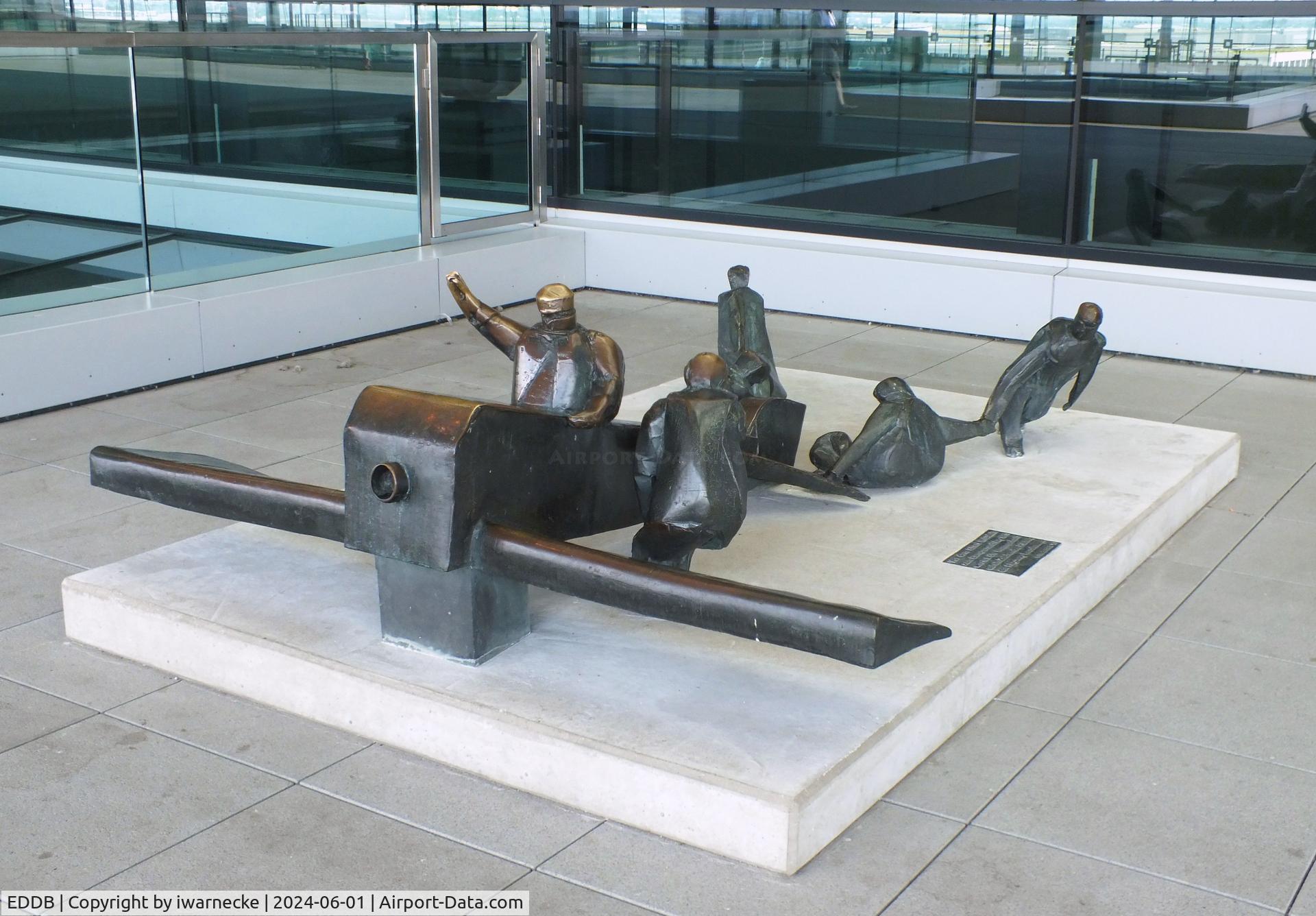 Berlin Brandenburg International Airport, Berlin Germany (EDDB) - sculpture 'Vor dem Start in Calais zum Europarundflug 1911 wartet die Mannschaft auf ein Zeichen des Piloten, das Flugzeug loszulassen' (at the take off in Calais 1911 the crew awaits a signal of the pilot to let go) 1983 by K. Biederbick at BER airport