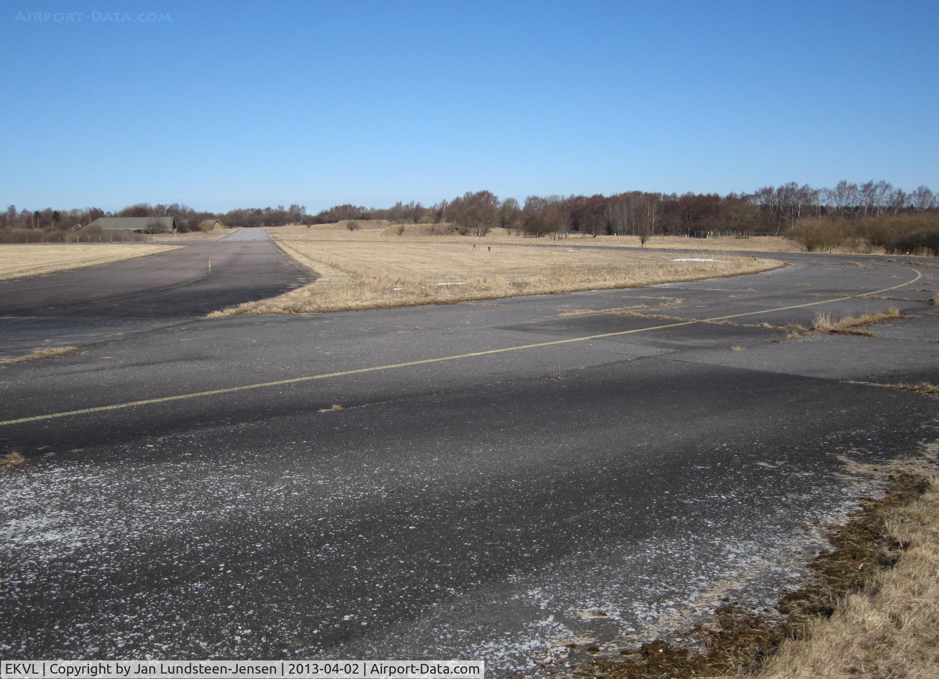 EKVL Airport - Seen from the edge of the runway in the eastern part of the closed Vaerloese Air Base in Denmark: To the left Taxiway Alpha. The curved taxiway-like section to the right was used for parking of military aircraft from foreign NATO countries.