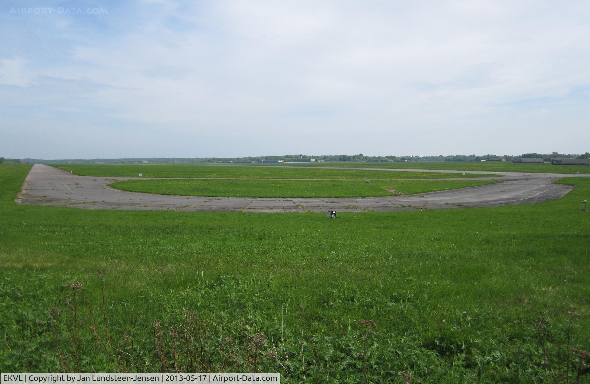 EKVL Airport - The north-western part of the closed Vaerloese Air Base in Denmark. To the left taxiway parallel to runway and towards the right Taxiway Echo straight to Runway 10. Curved section in foreground used for aircraft parking, mostly foreign NATO planes.