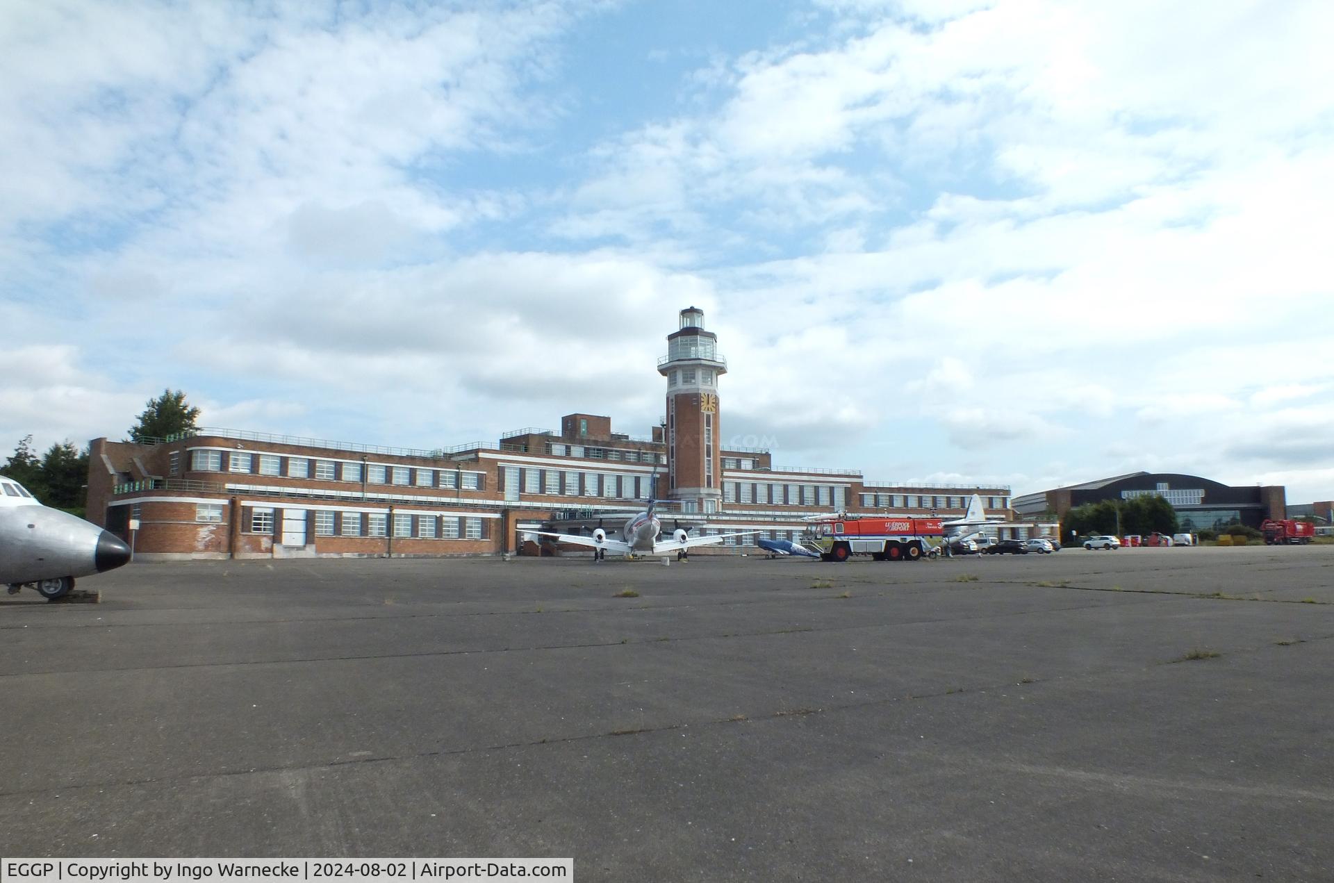 Liverpool John Lennon Airport, Liverpool, England United Kingdom (EGGP) - airside view of the old 1930s terminal, tower (today a Crowne Plaza hotel) and hangar with exhibition of vehicles and aircraft preserved by the Speke Aerodrome Heritage Groups (SAHG) on the former apron 